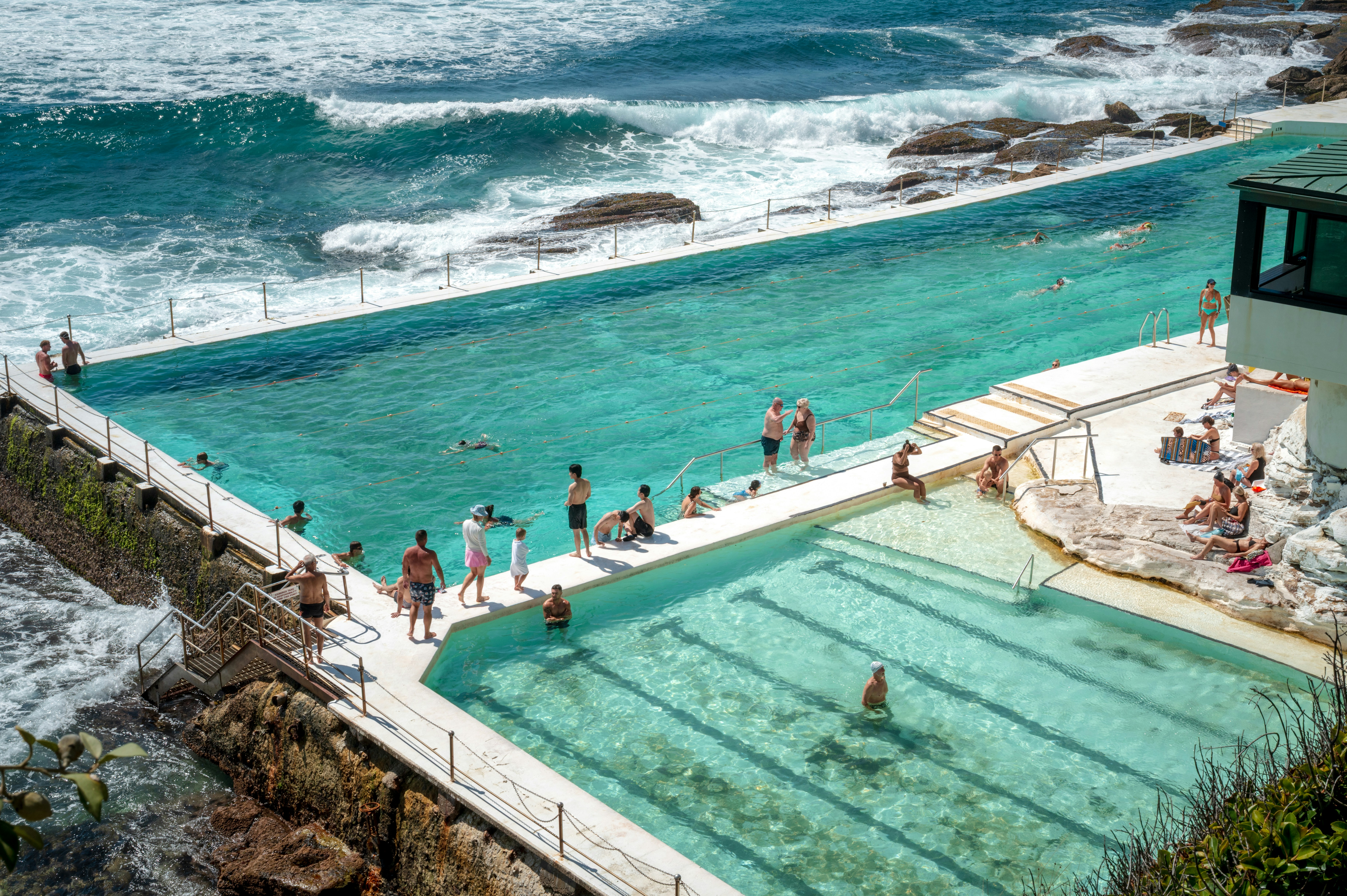 Piscina oceanica con persone che nuotano e prendono il sole.