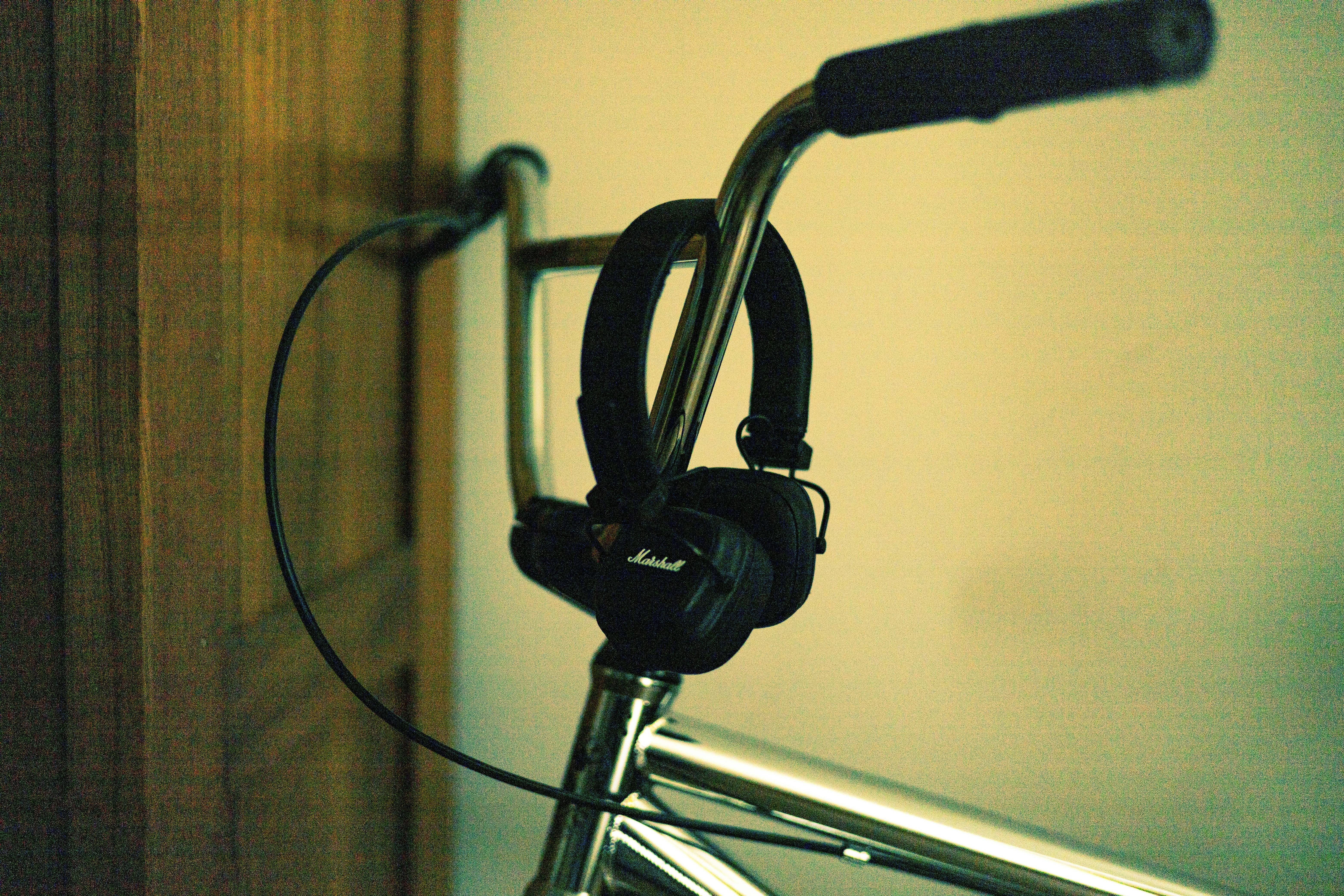 Headphones hanging from a bicycle handlebar.