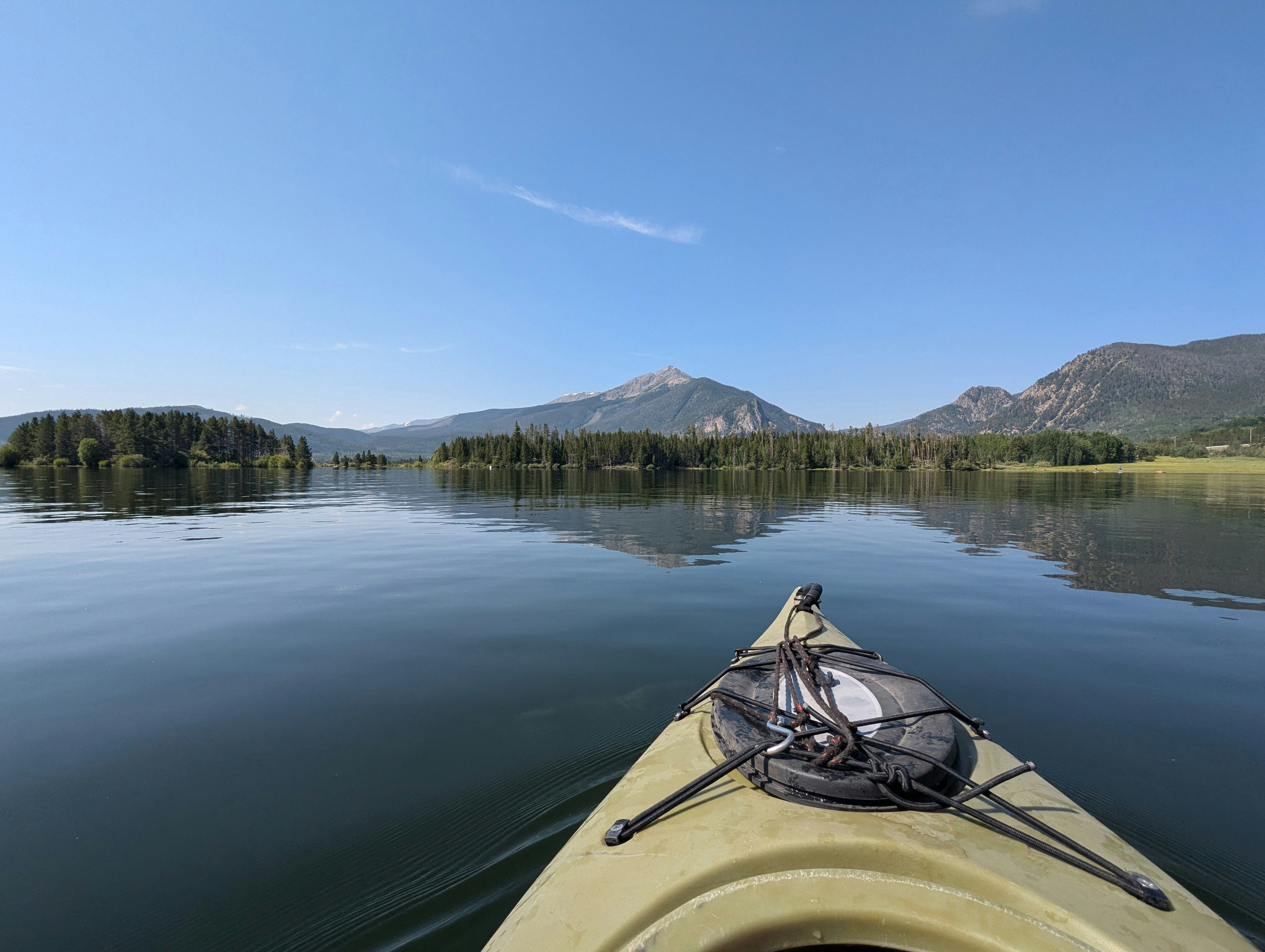 Kayaking on a calm lake with mountains in distance