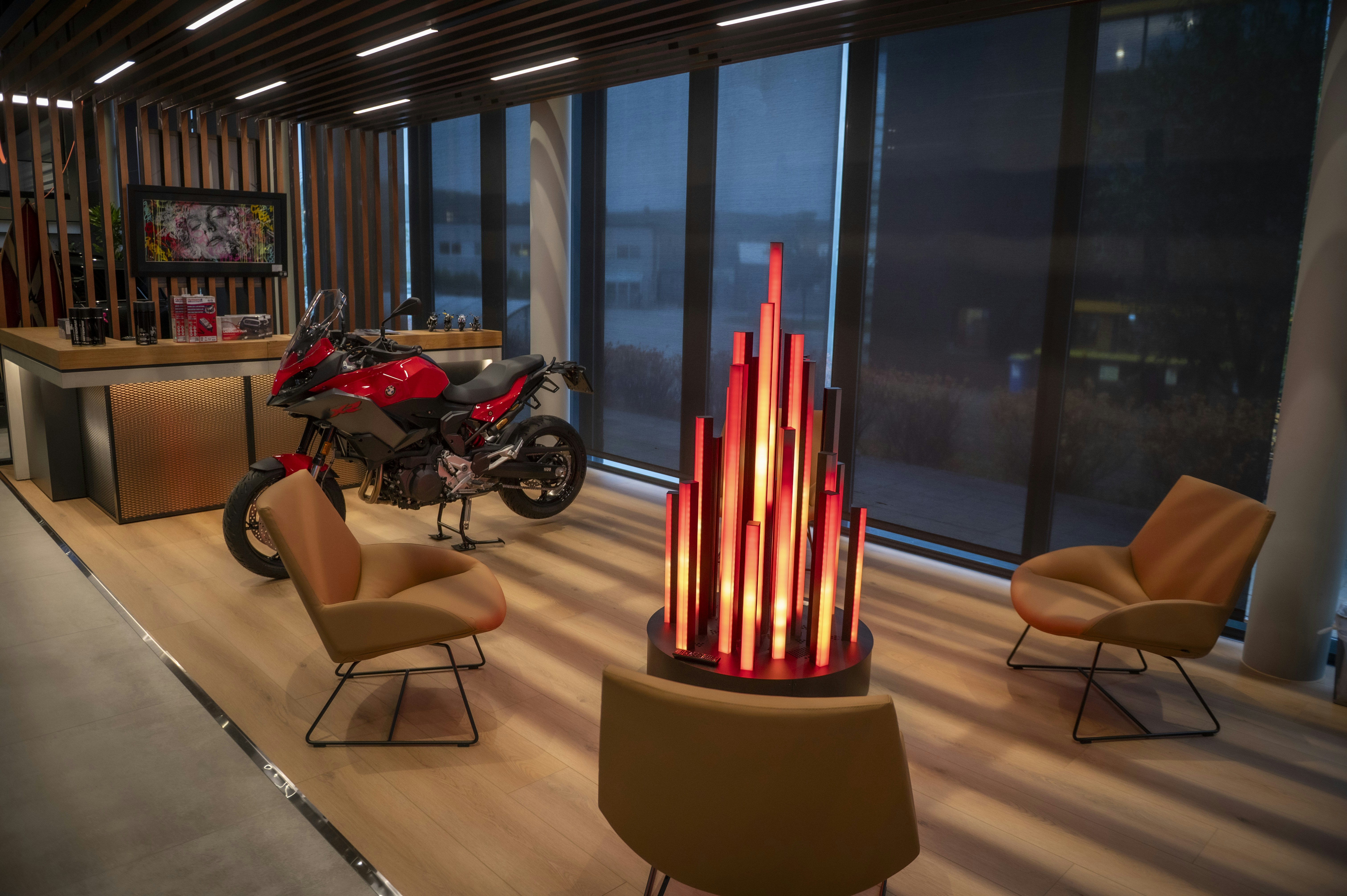 Modern lounge with motorcycle and abstract art installation.