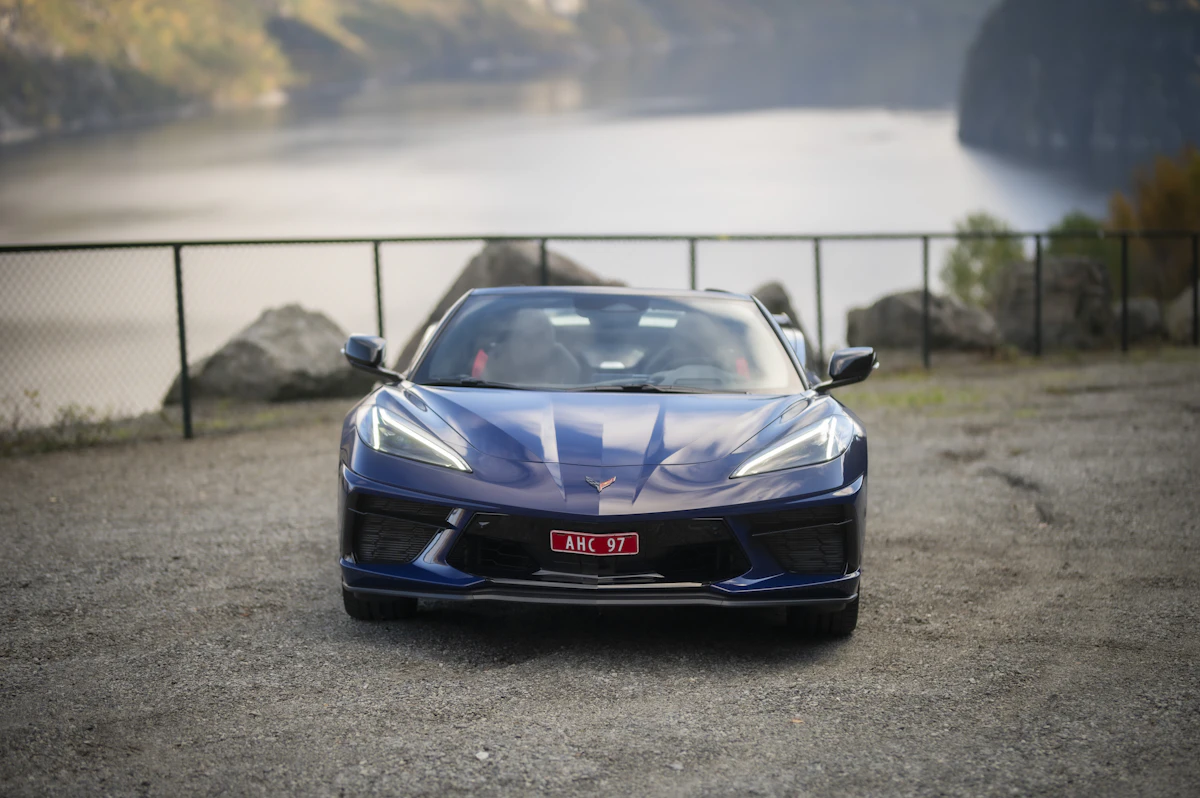 Sleek blue sports car with glossy paint finish parked outdoors near water