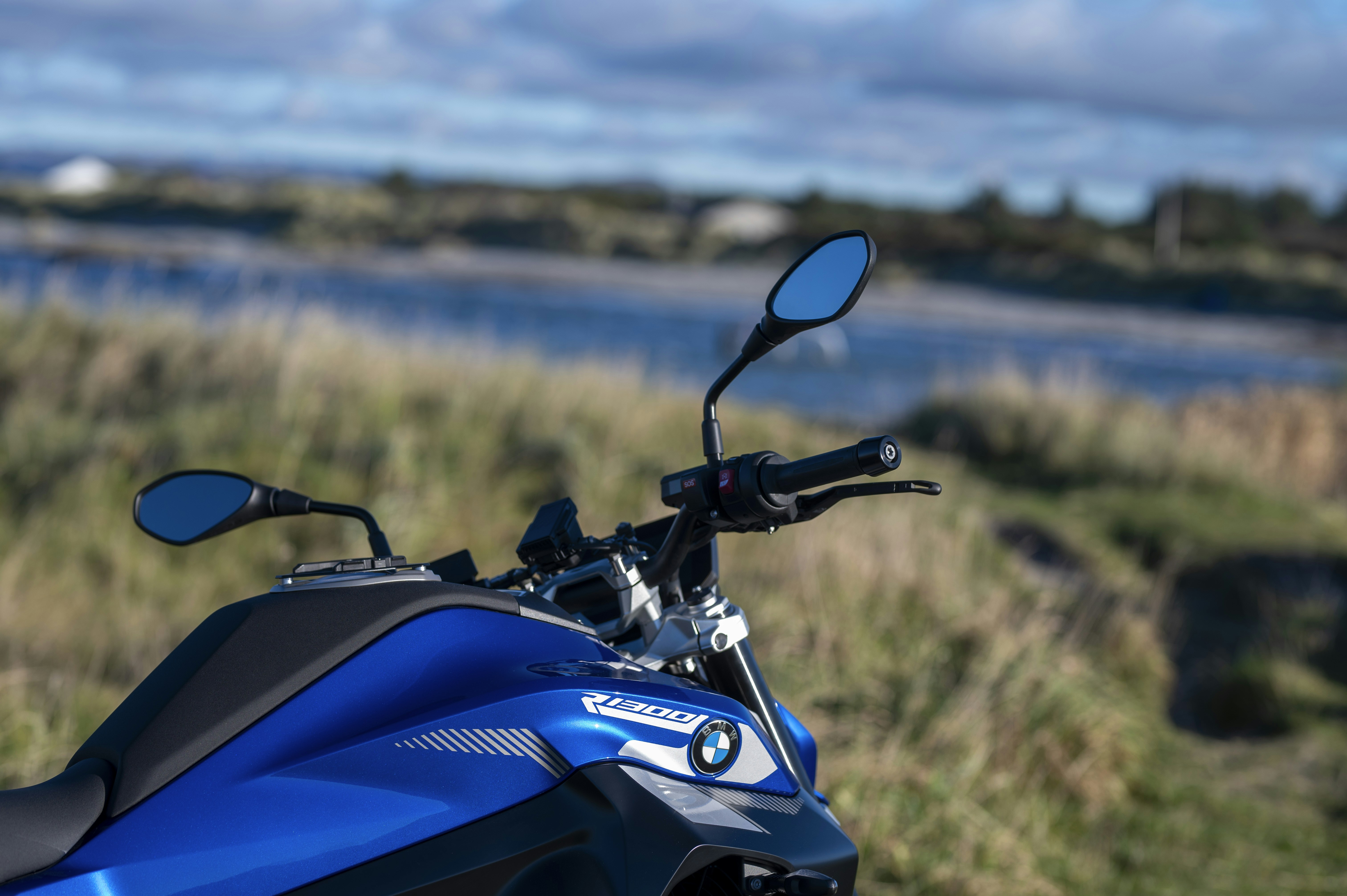 Blue motorcycle parked in a grassy landscape