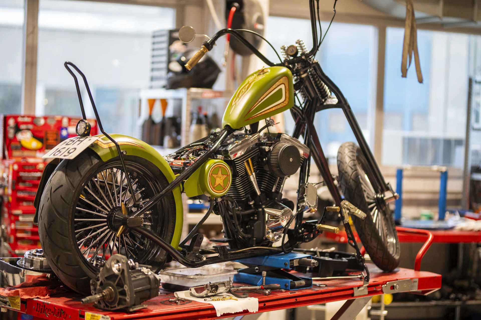 A custom green motorcycle being assembled in a workshop.