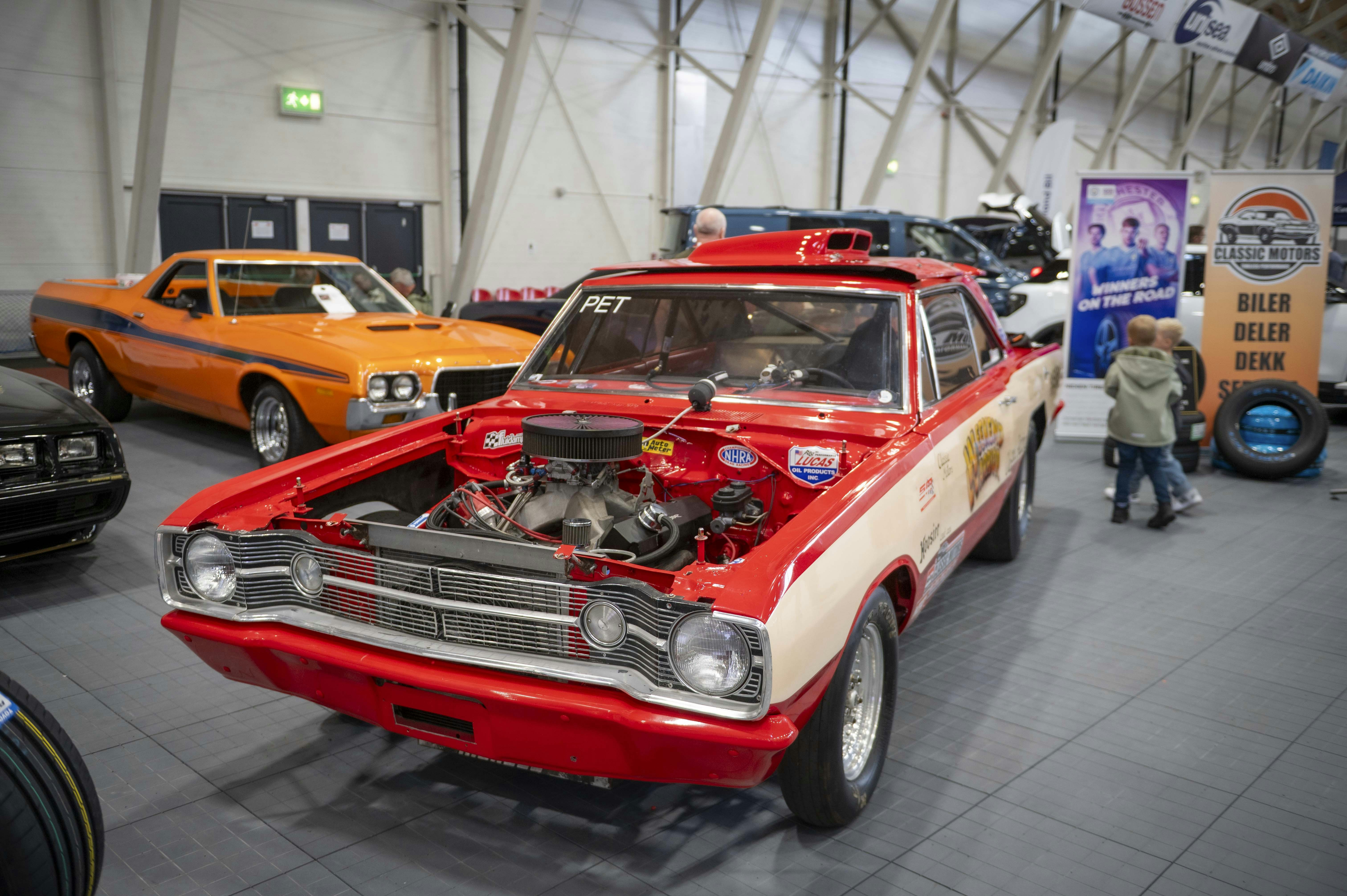 Red and white vintage car with open hood