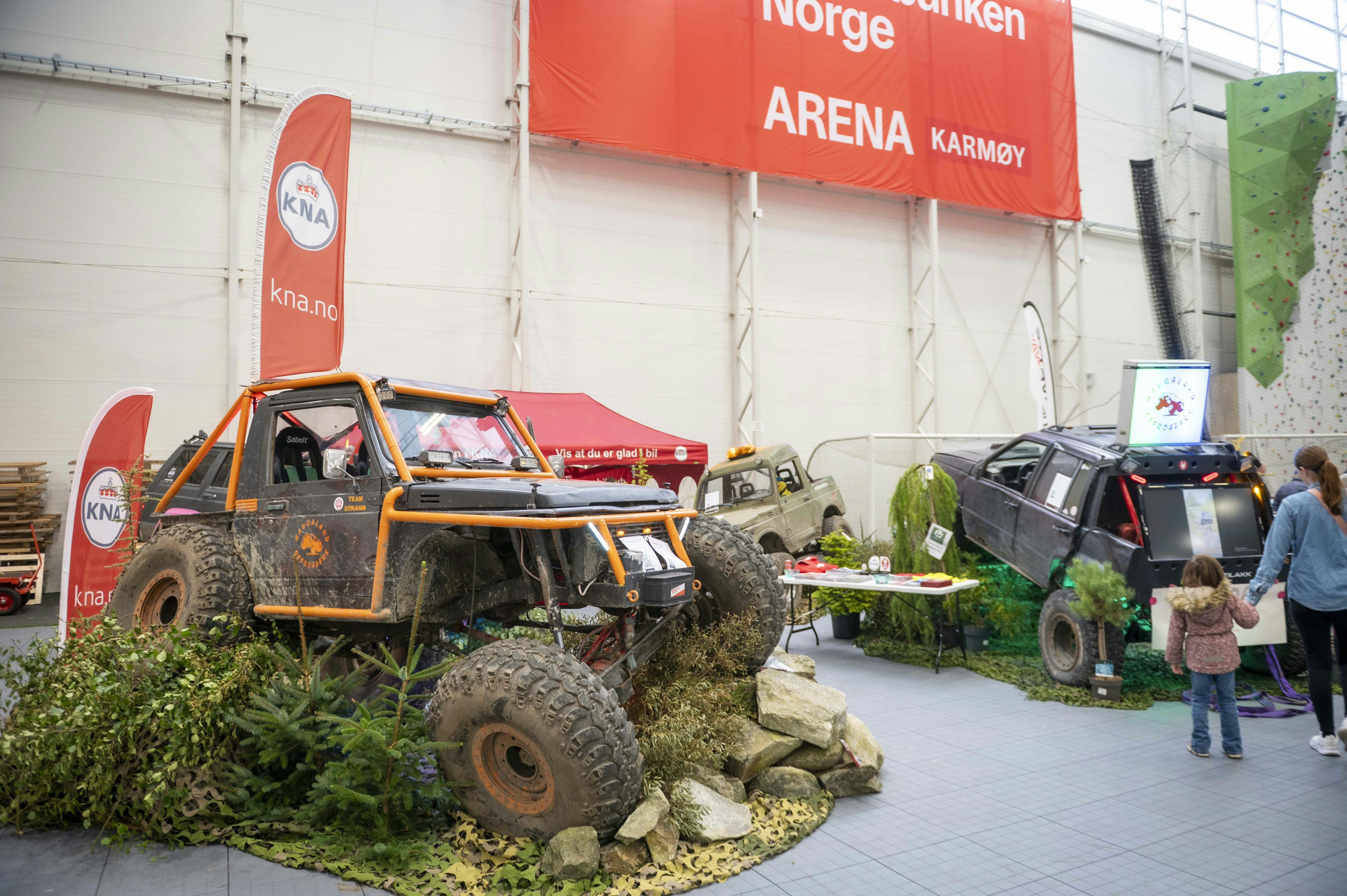 Off-road vehicles displayed with greenery and rocks