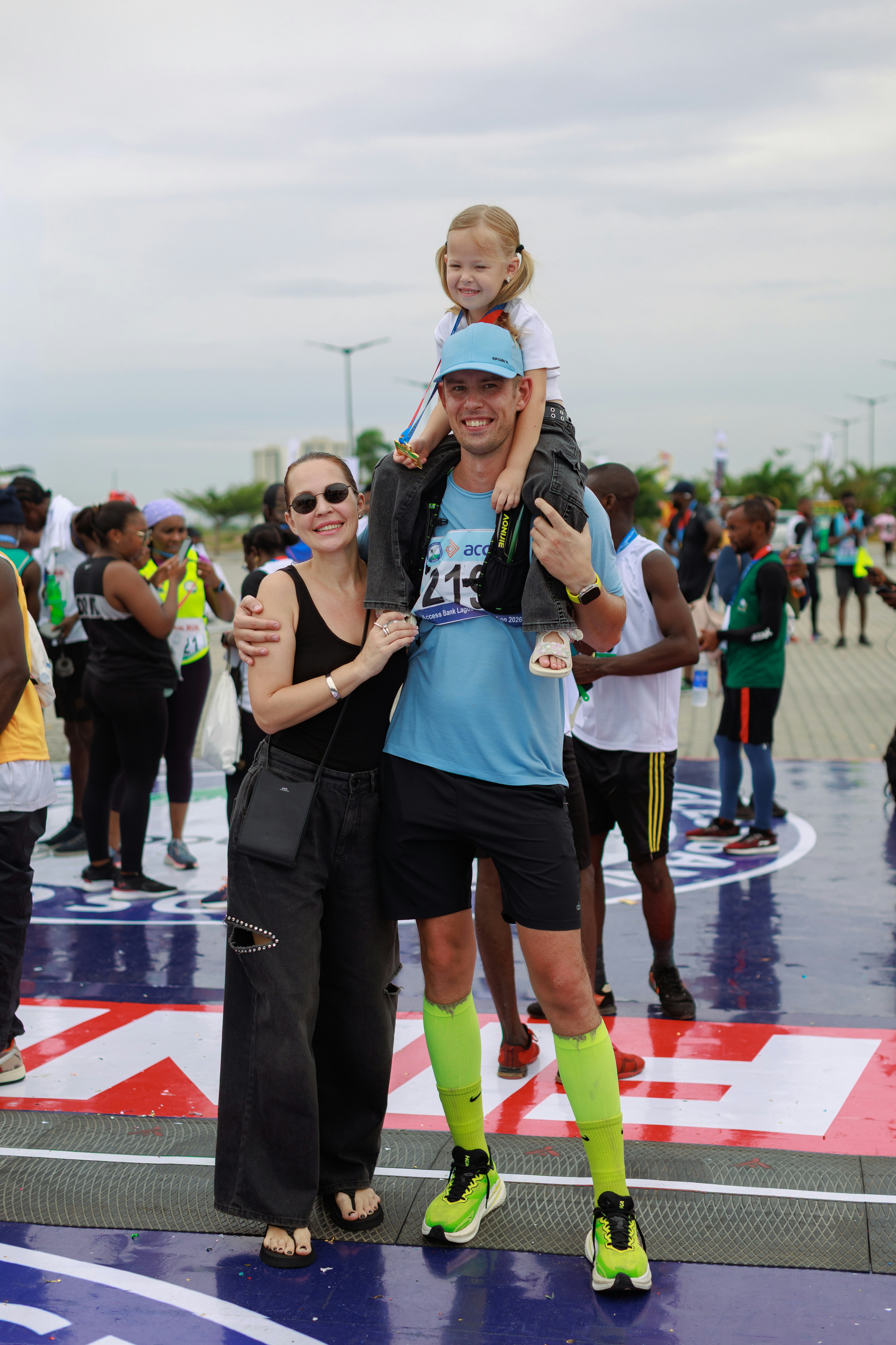 Familia posando tras una carrera con la hija sobre los hombros