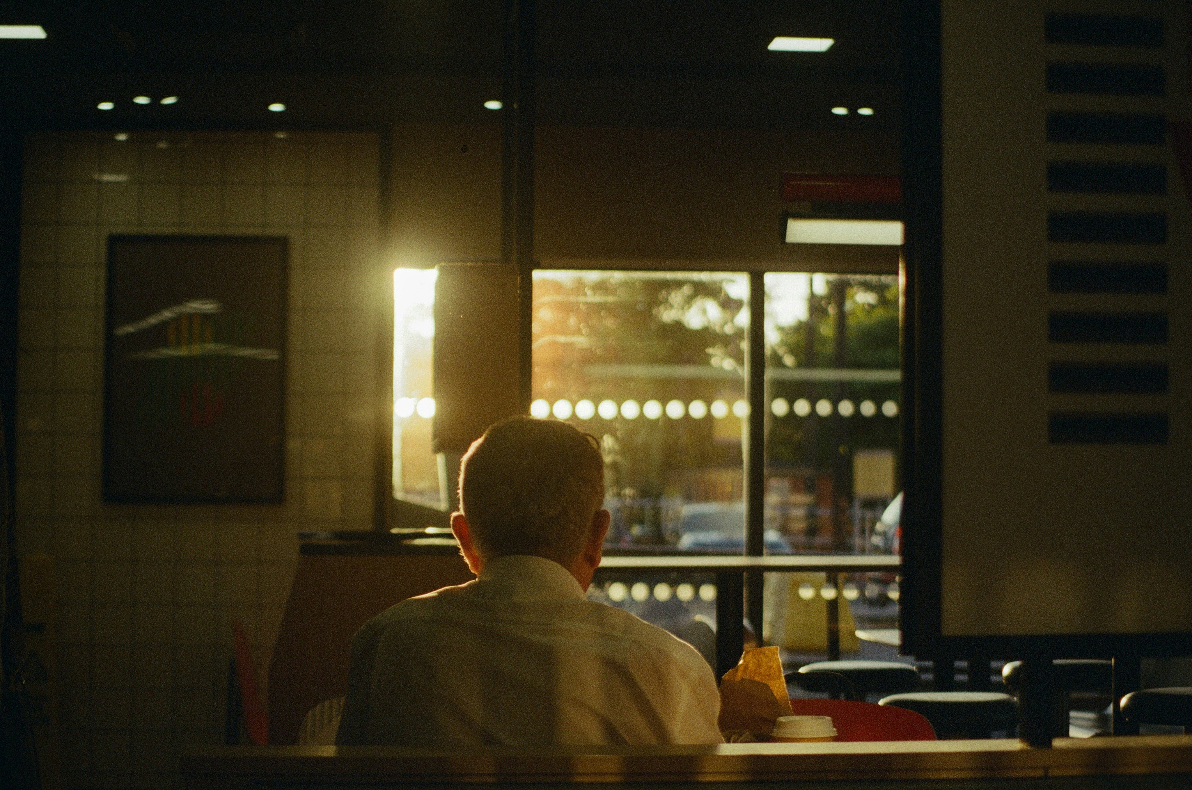 Man sitting indoors with sunset light streaming in.