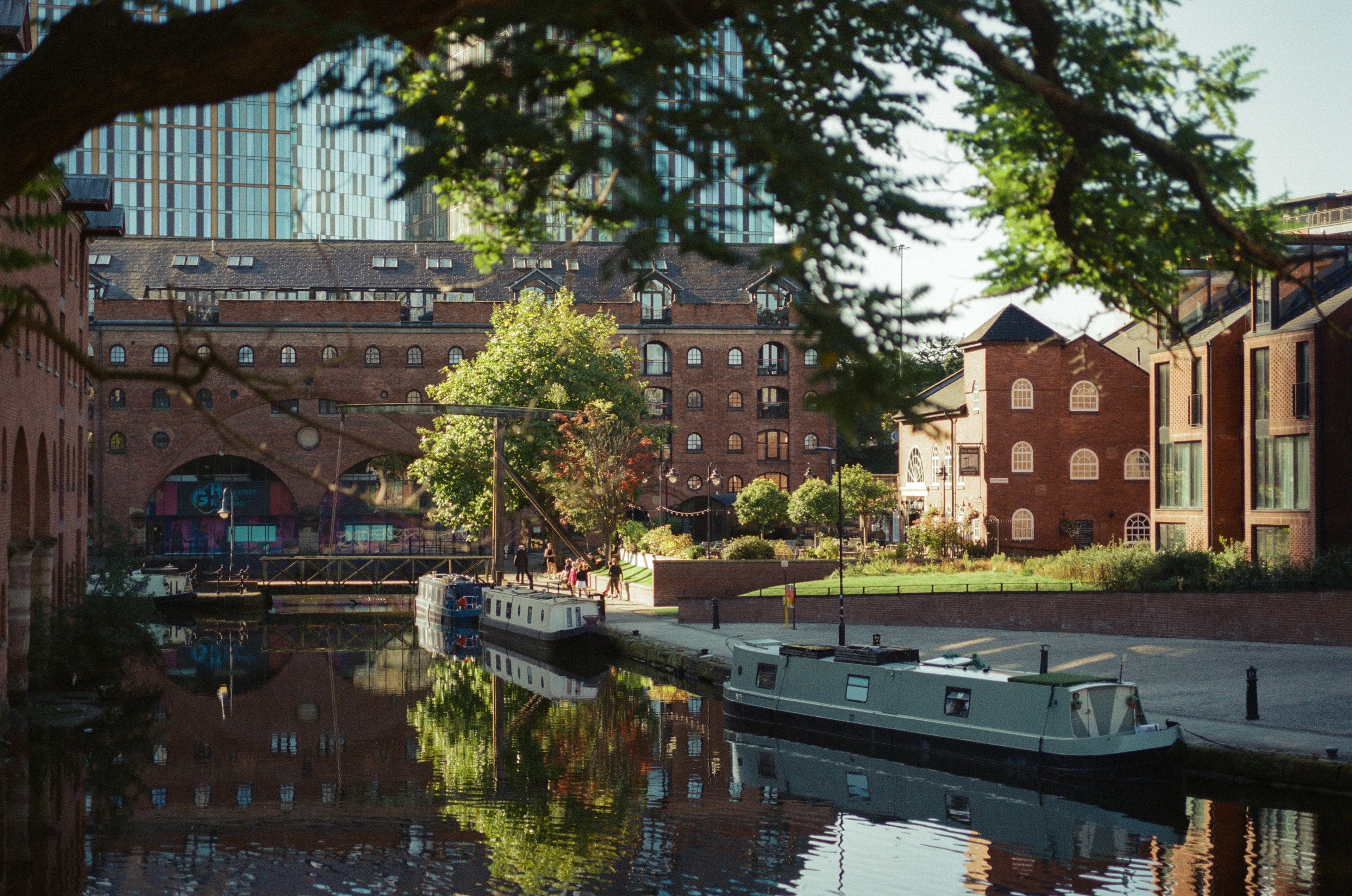 Narrowboats moored in the Castlefield basin, Manchester, under the old brick viaducts
