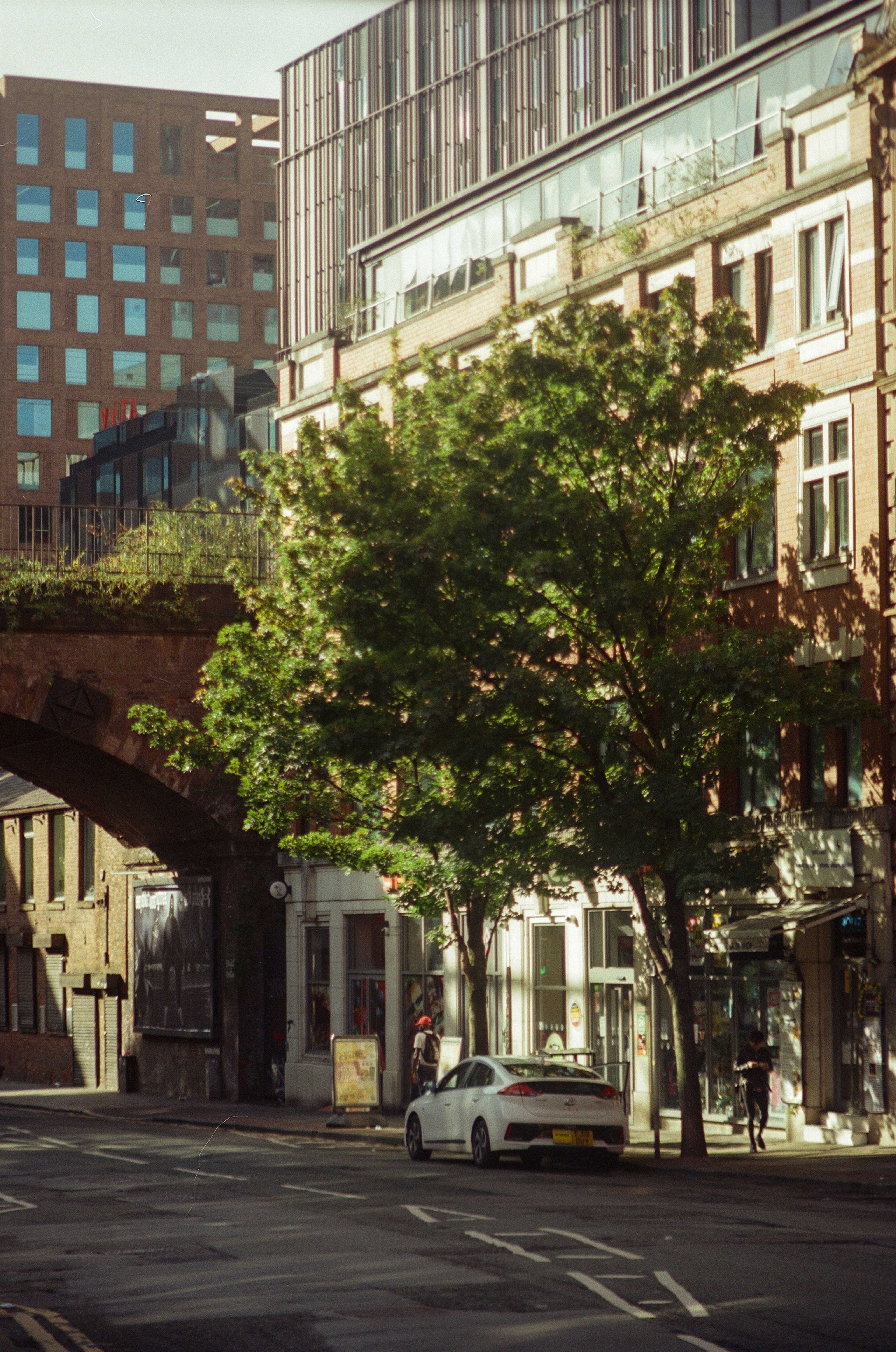 A white car parked on a city street near buildings.