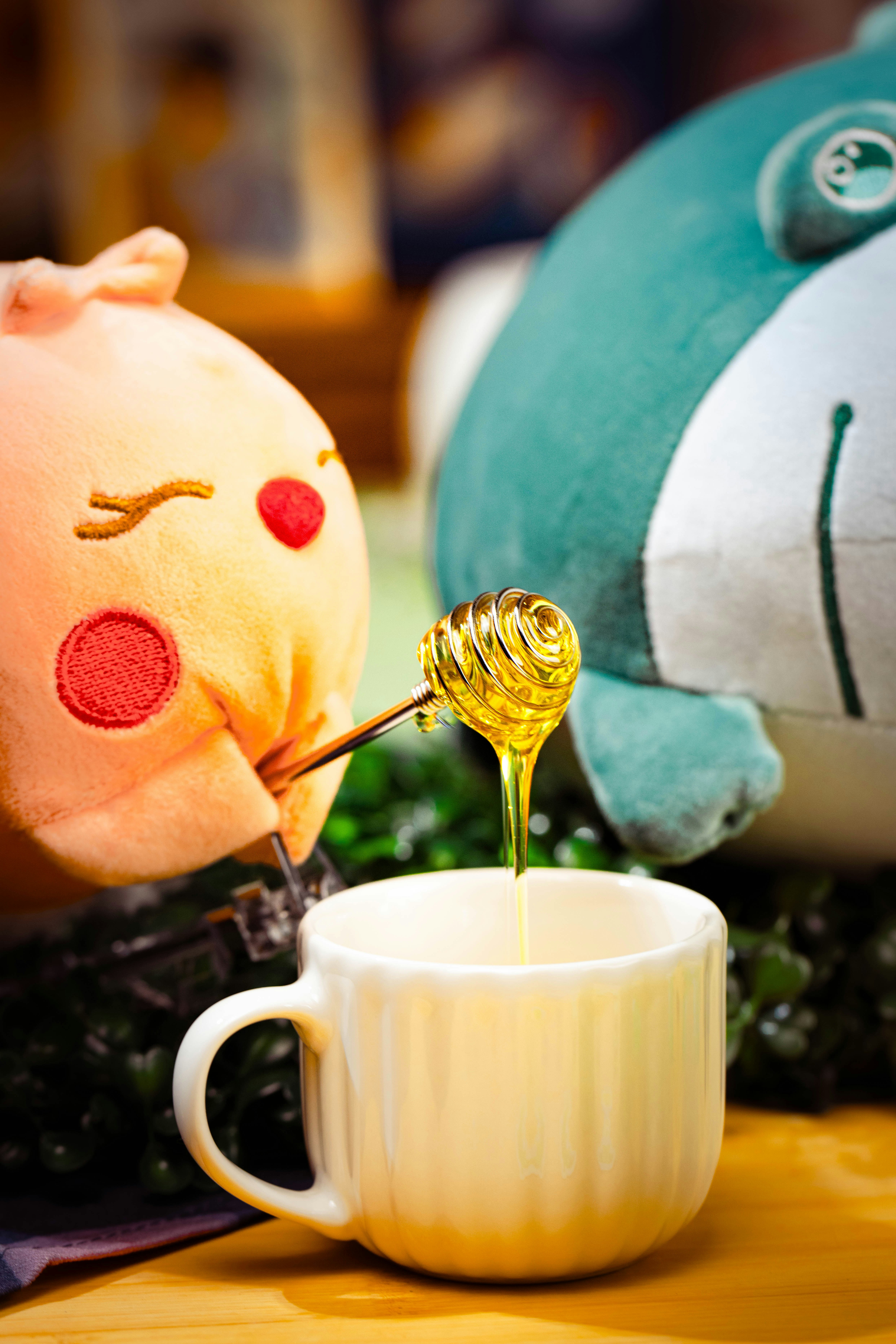 Honey dripping from dipper into white mug