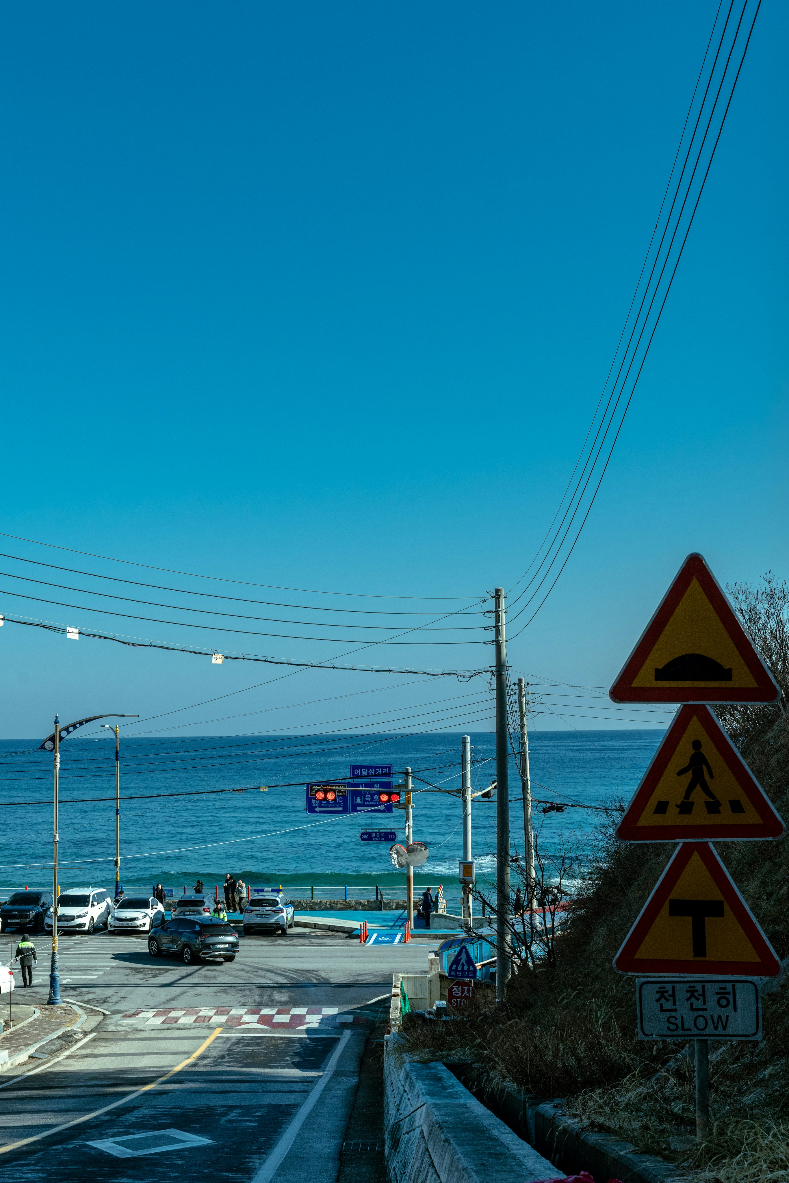 Road signs by the ocean with clear blue sky