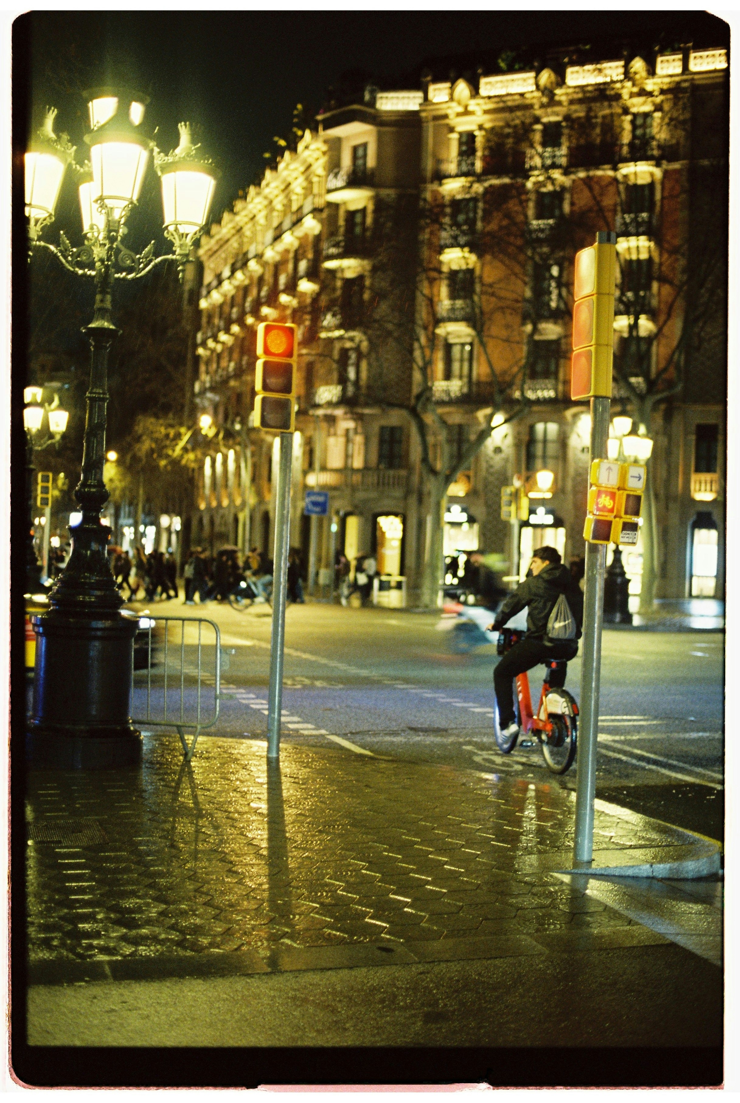 Man riding a bicycle at night on wet street