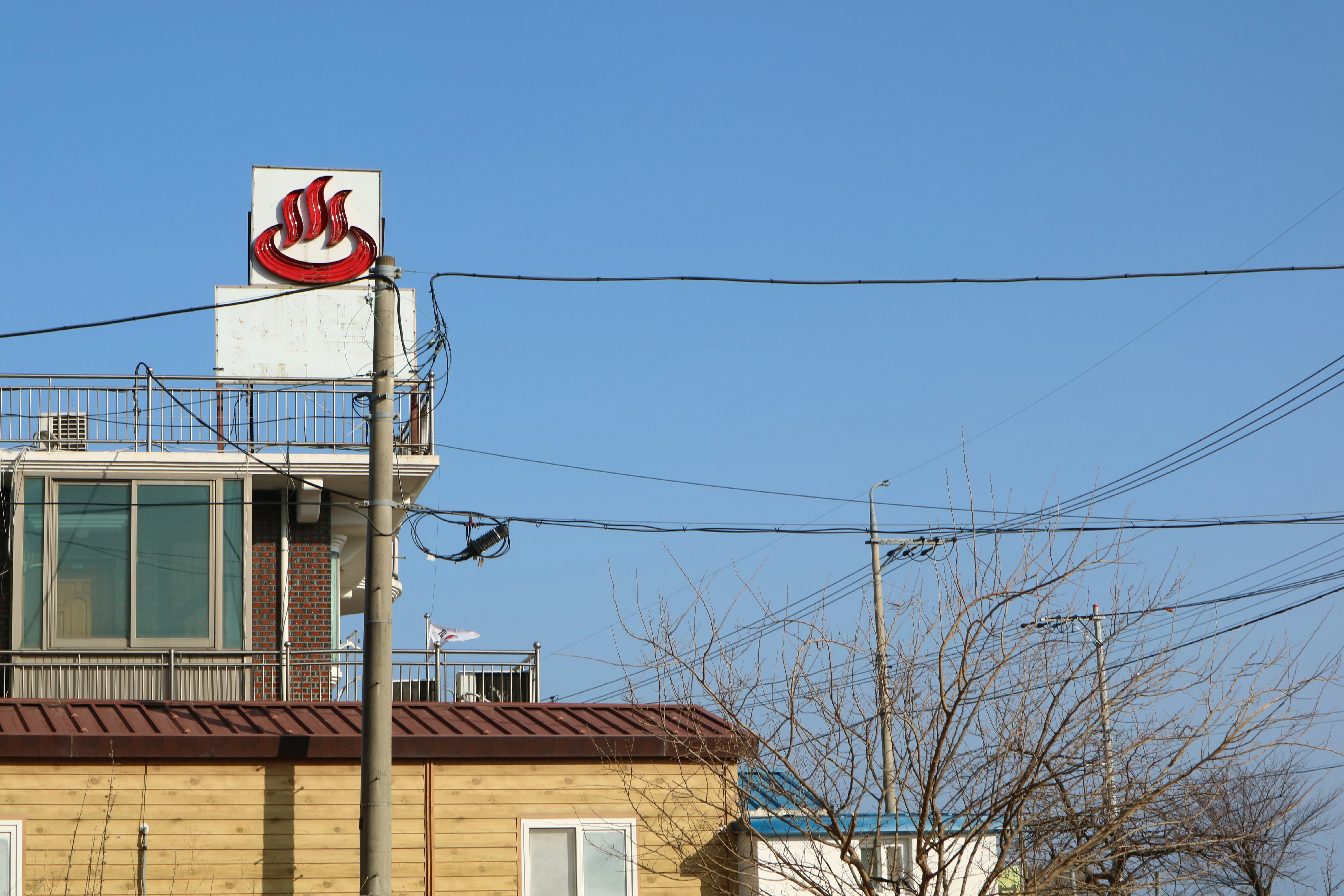 Building with a red and white sign against blue sky