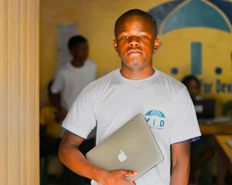 Young man holding a laptop in a room