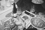 Table with food, drinks, and candles after-dinner mess.