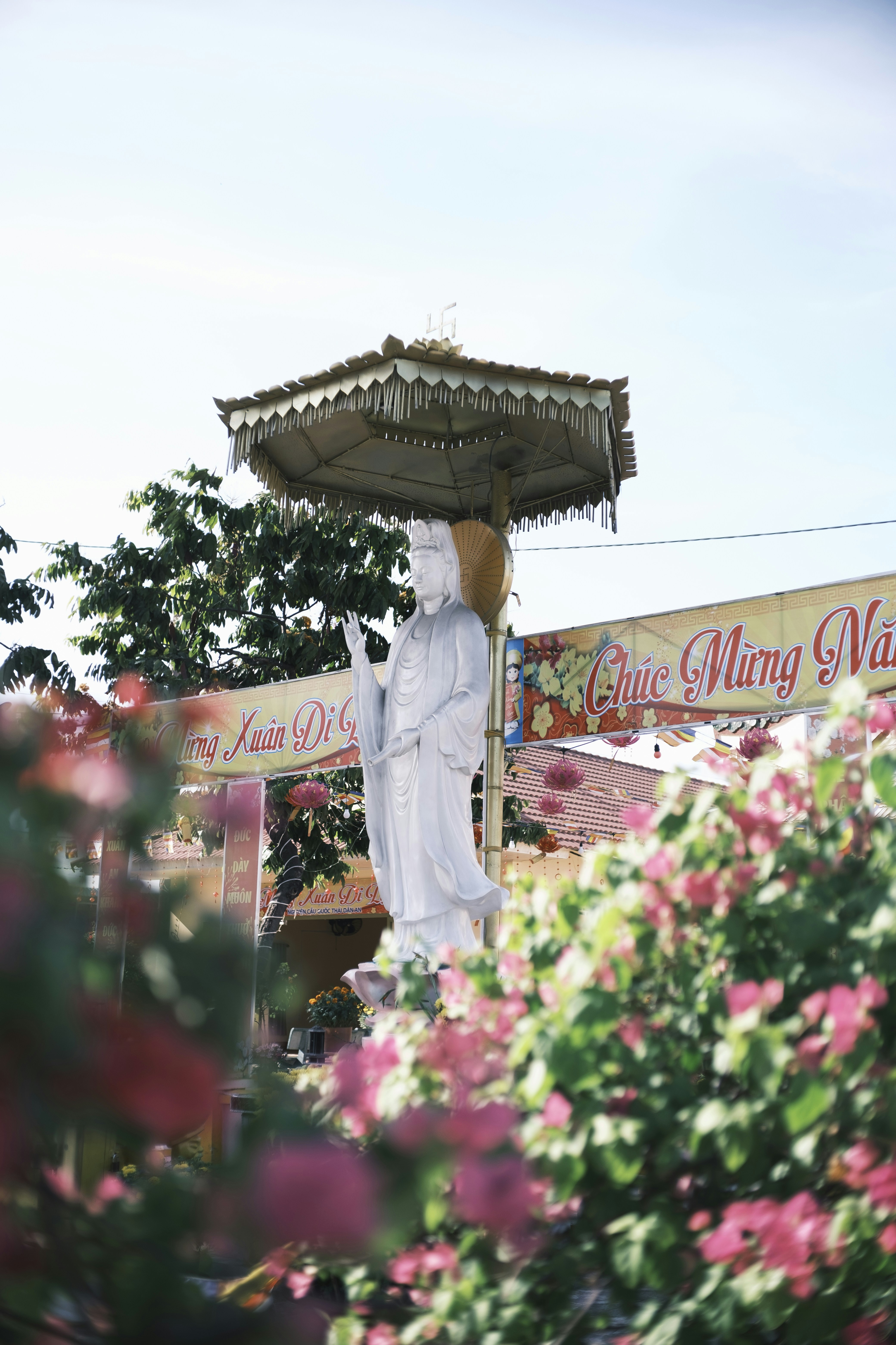 White statue under ornate canopy with flowers