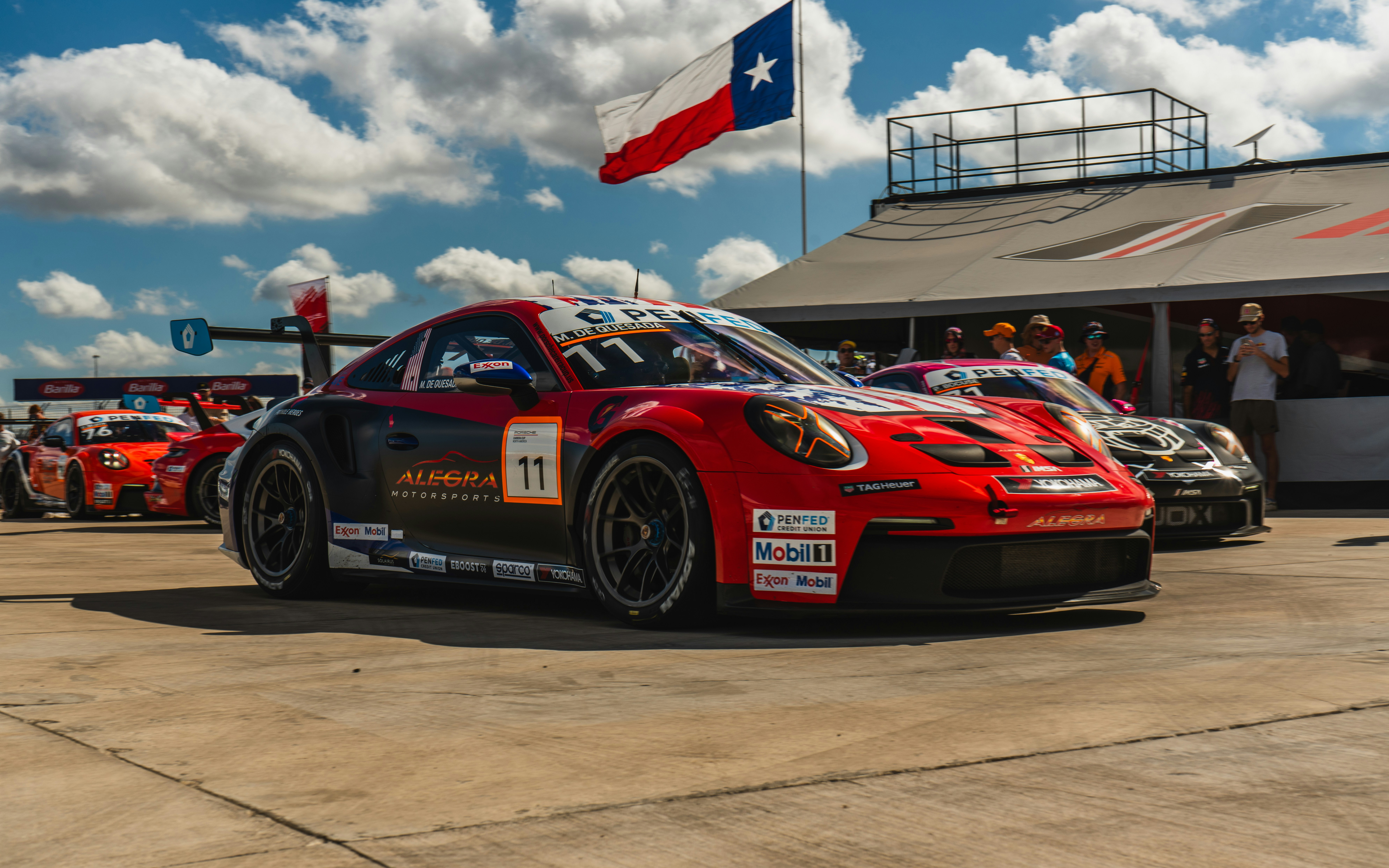 Auto da corsa rossa con numero 11 e bandiera del Texas