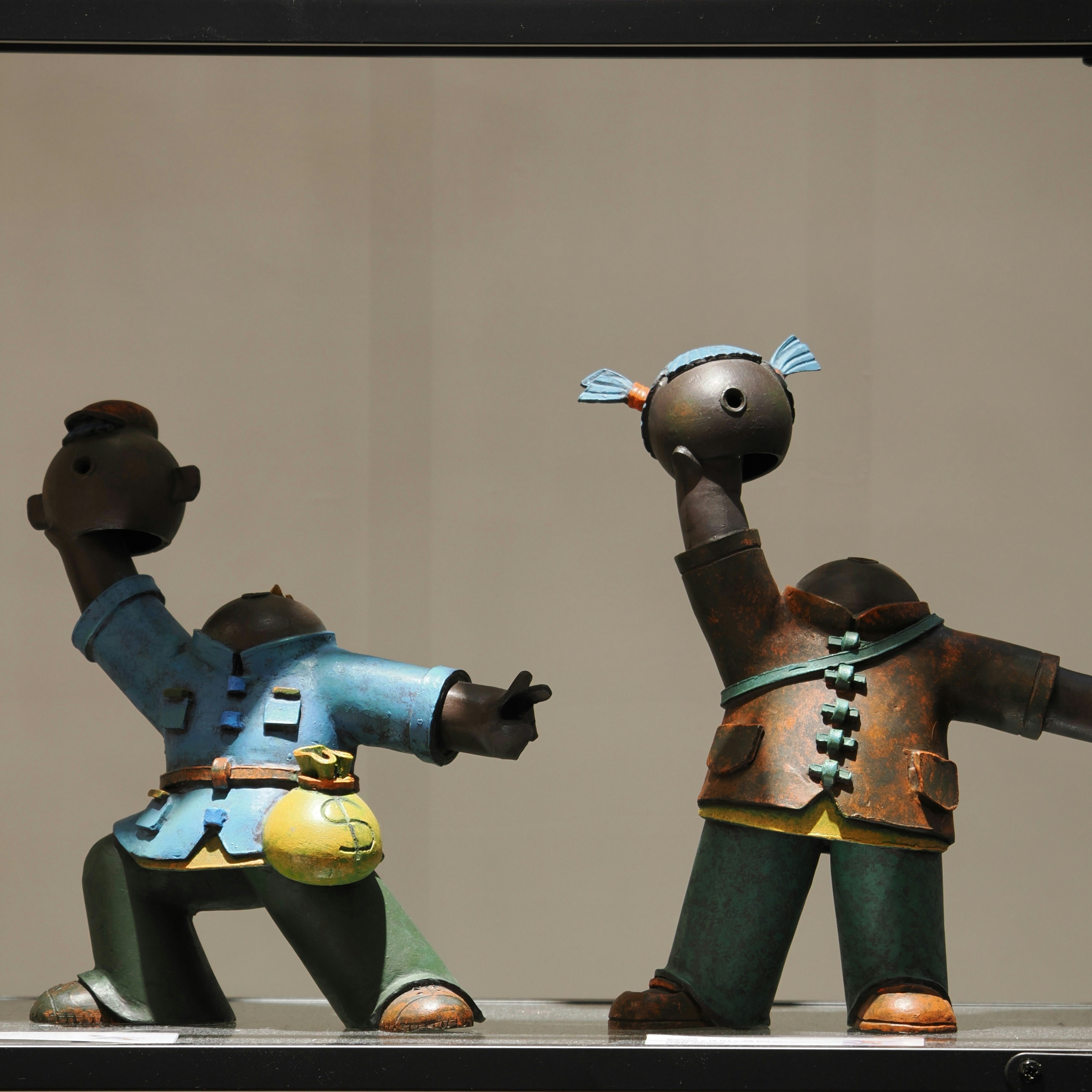 Two cartoon figures in traditional clothing on display