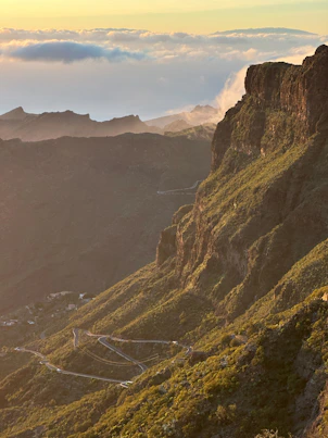 Winding mountain road through a green, rugged landscape