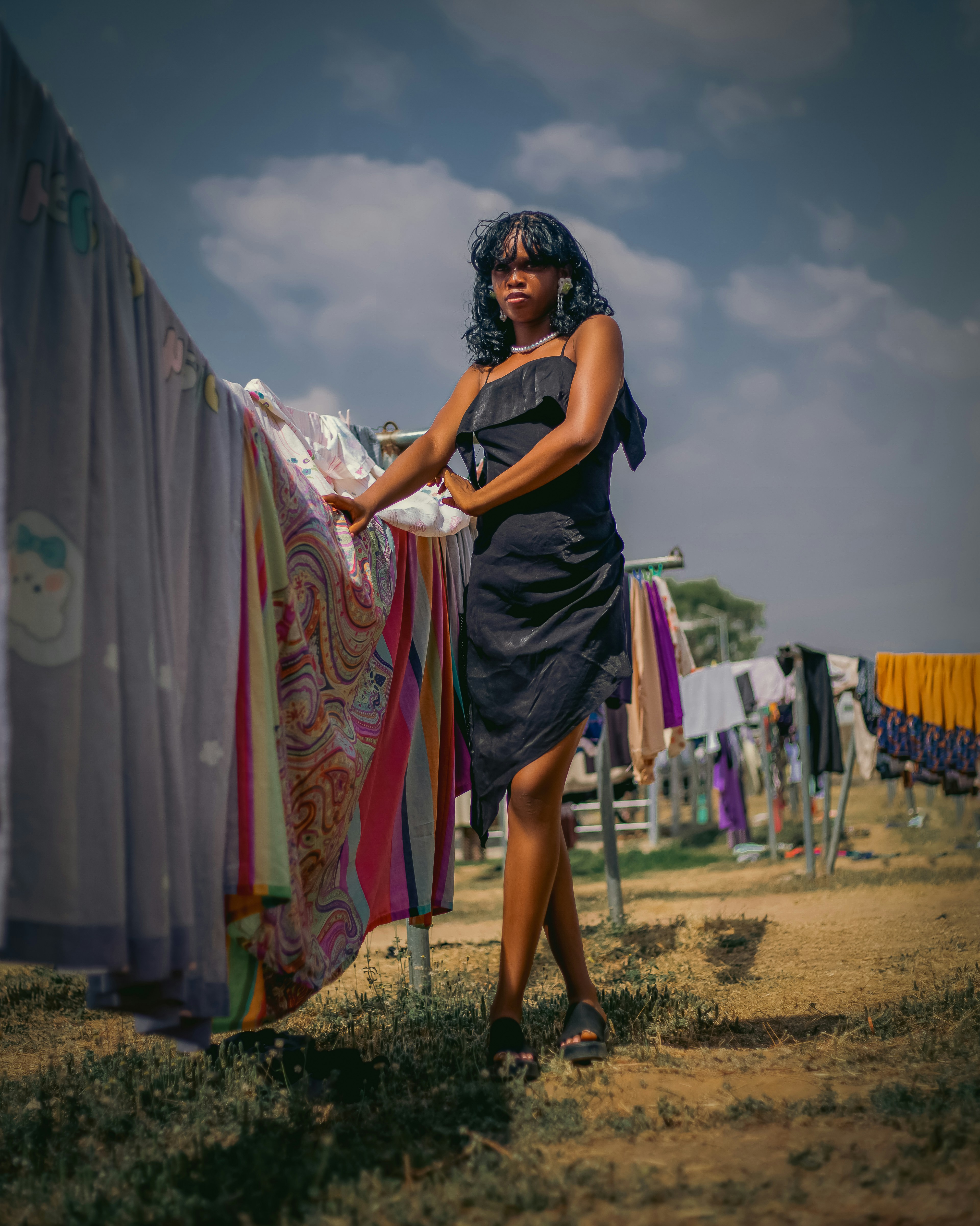 Giovane donna in abito nero in attesa allo stendibiancheria