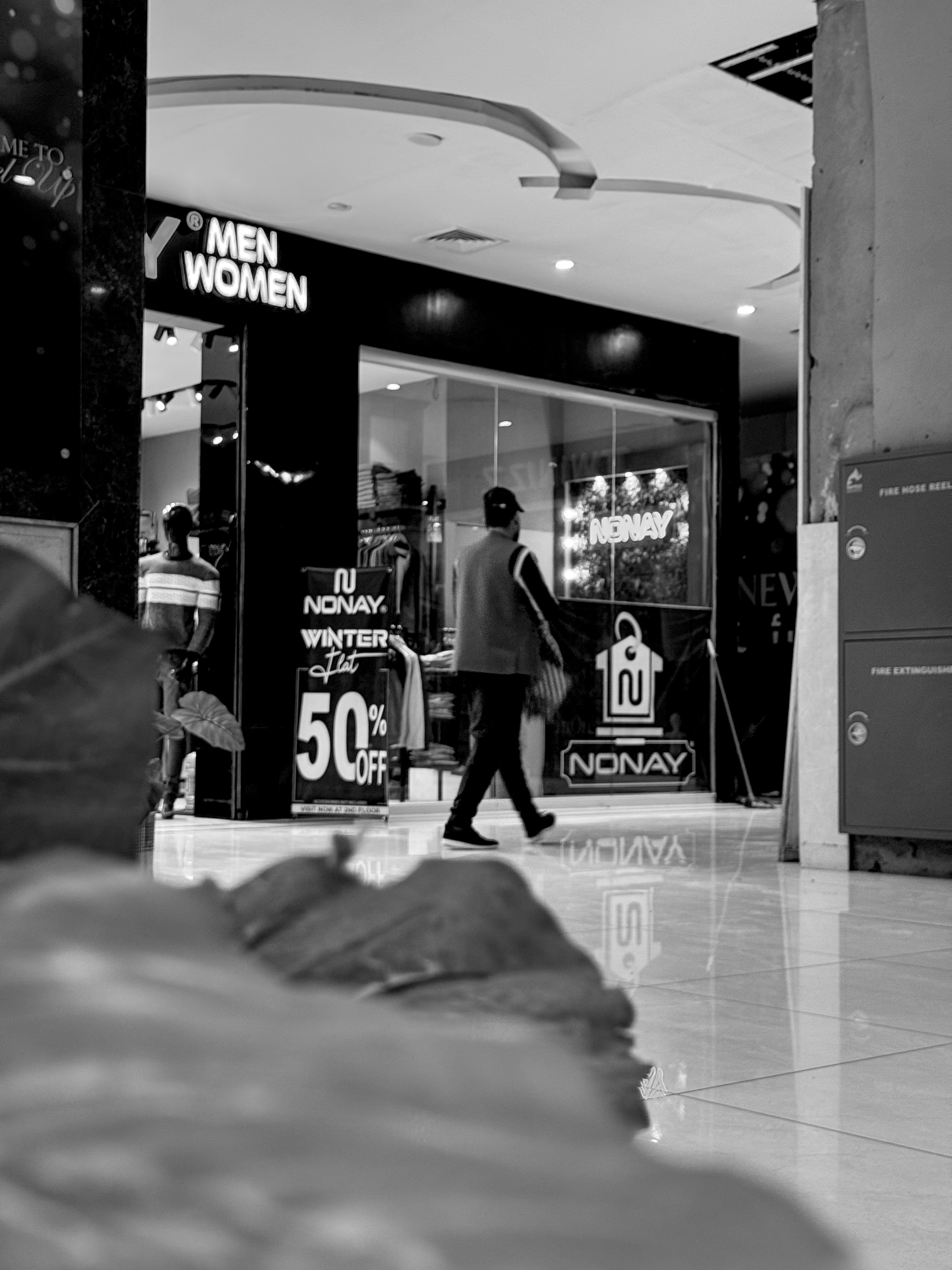 Man walks past a store with sale signs