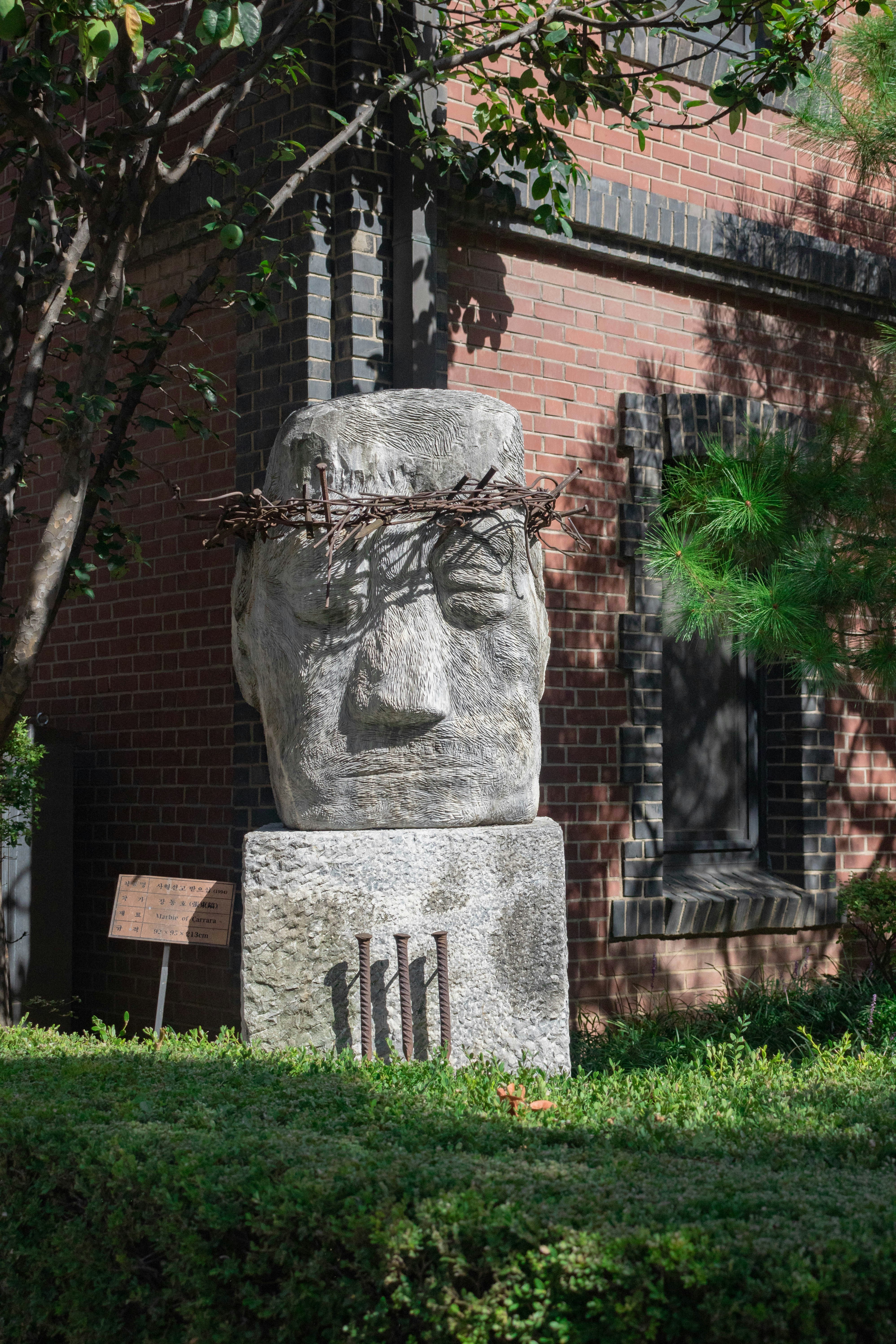 Escultura de piedra de una cabeza con una corona de espinas.