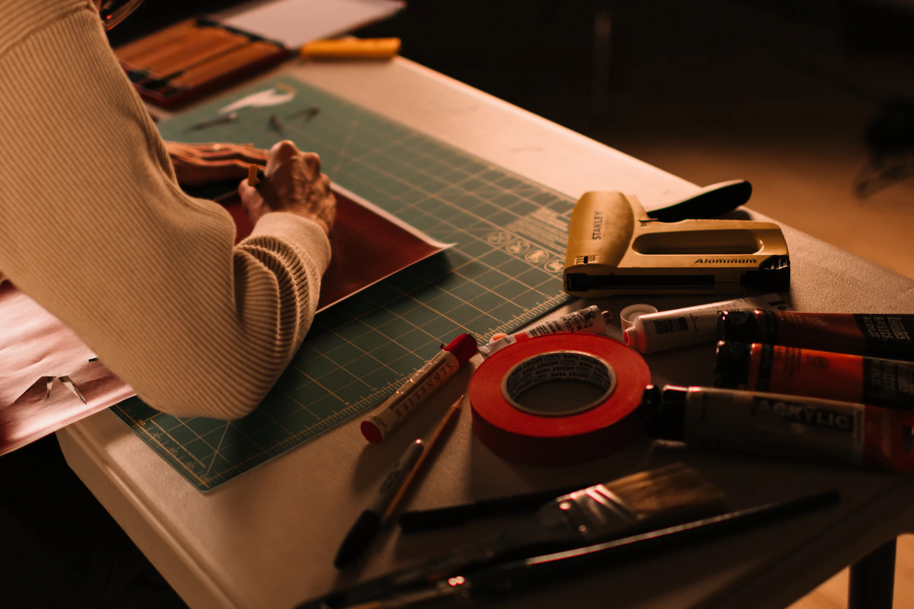 Mãos trabalhando em um projeto criativo com materiais de arte