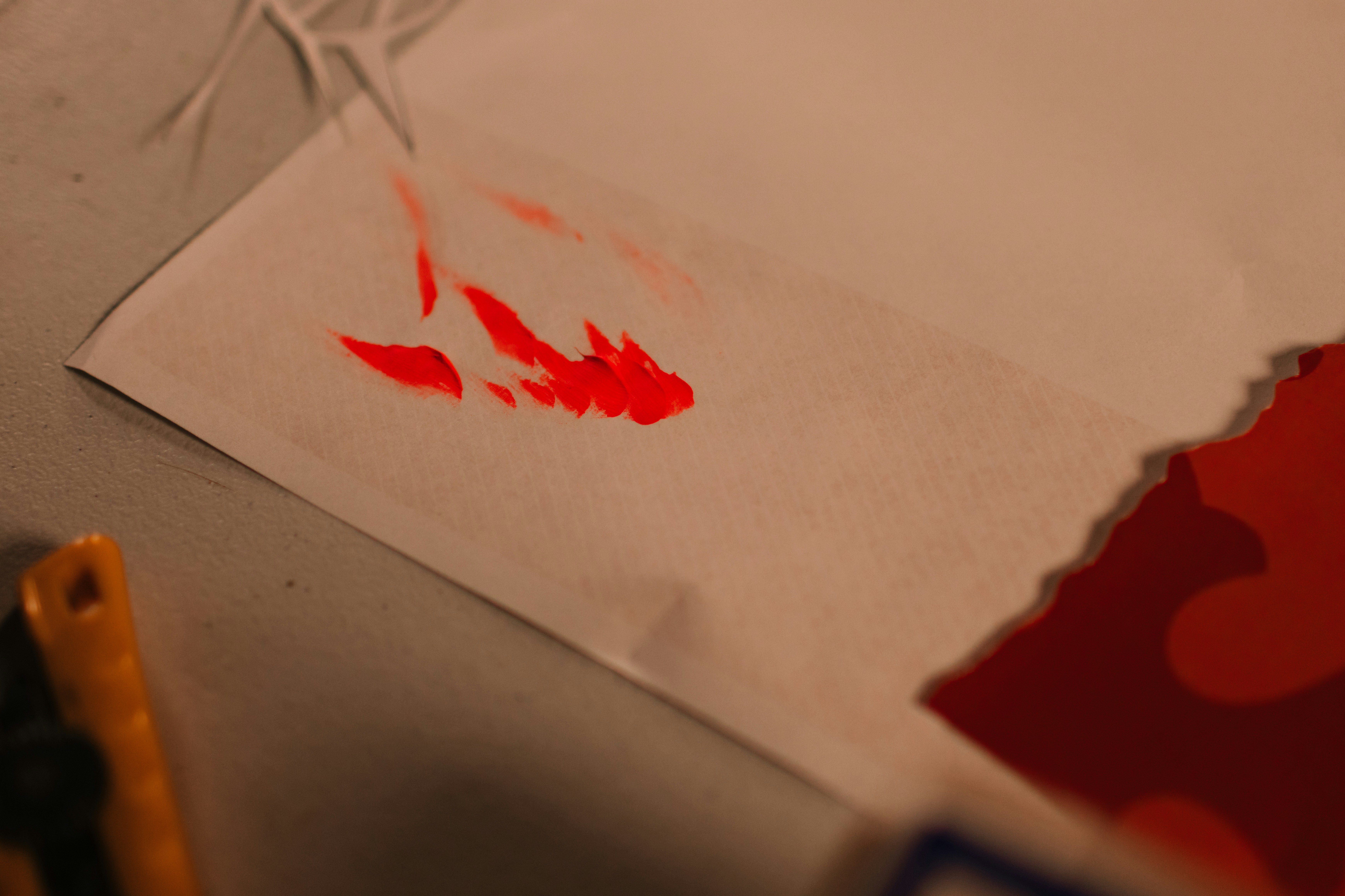 Red paint splatters on white paper