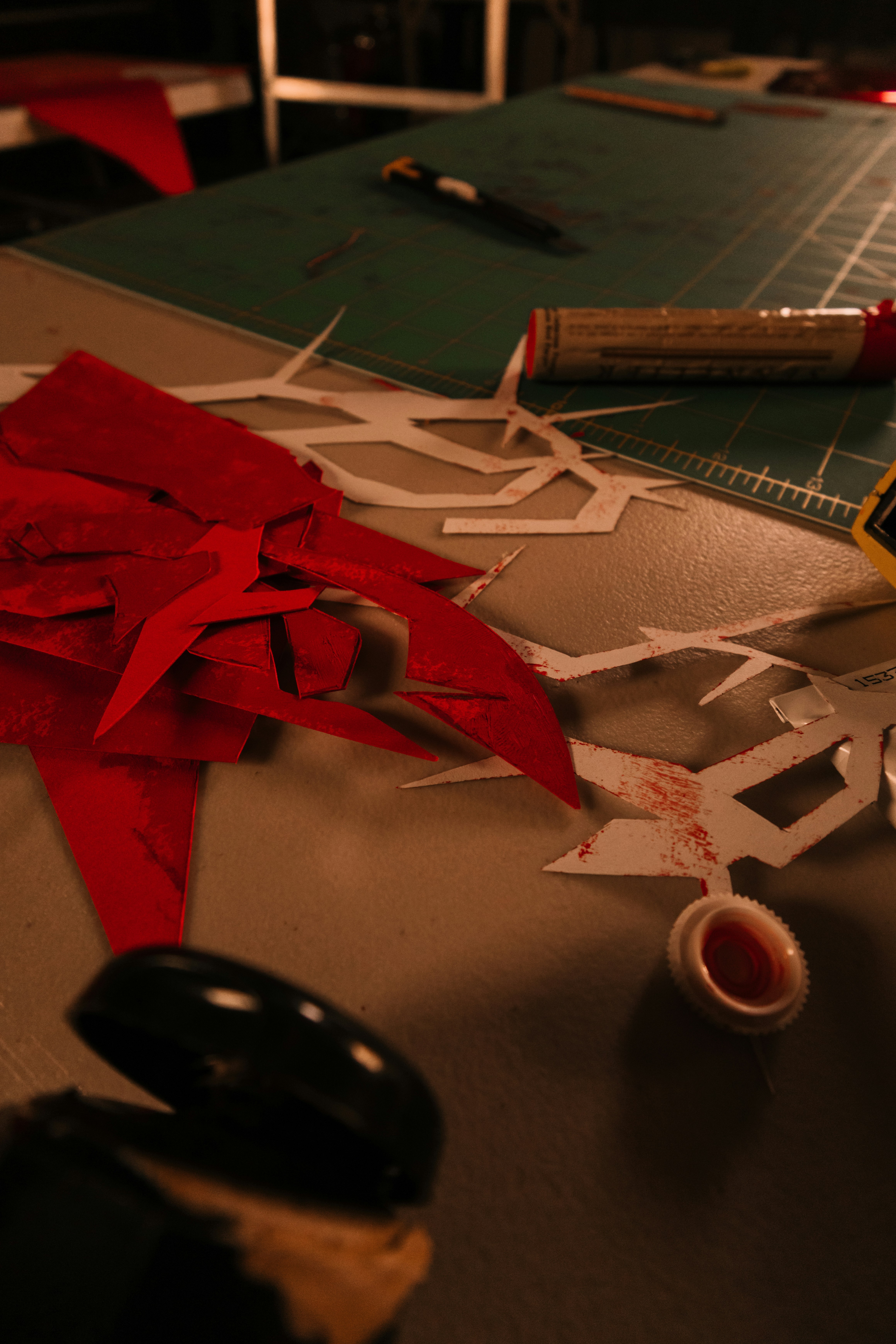 Red paper scraps and crafting tools on a table