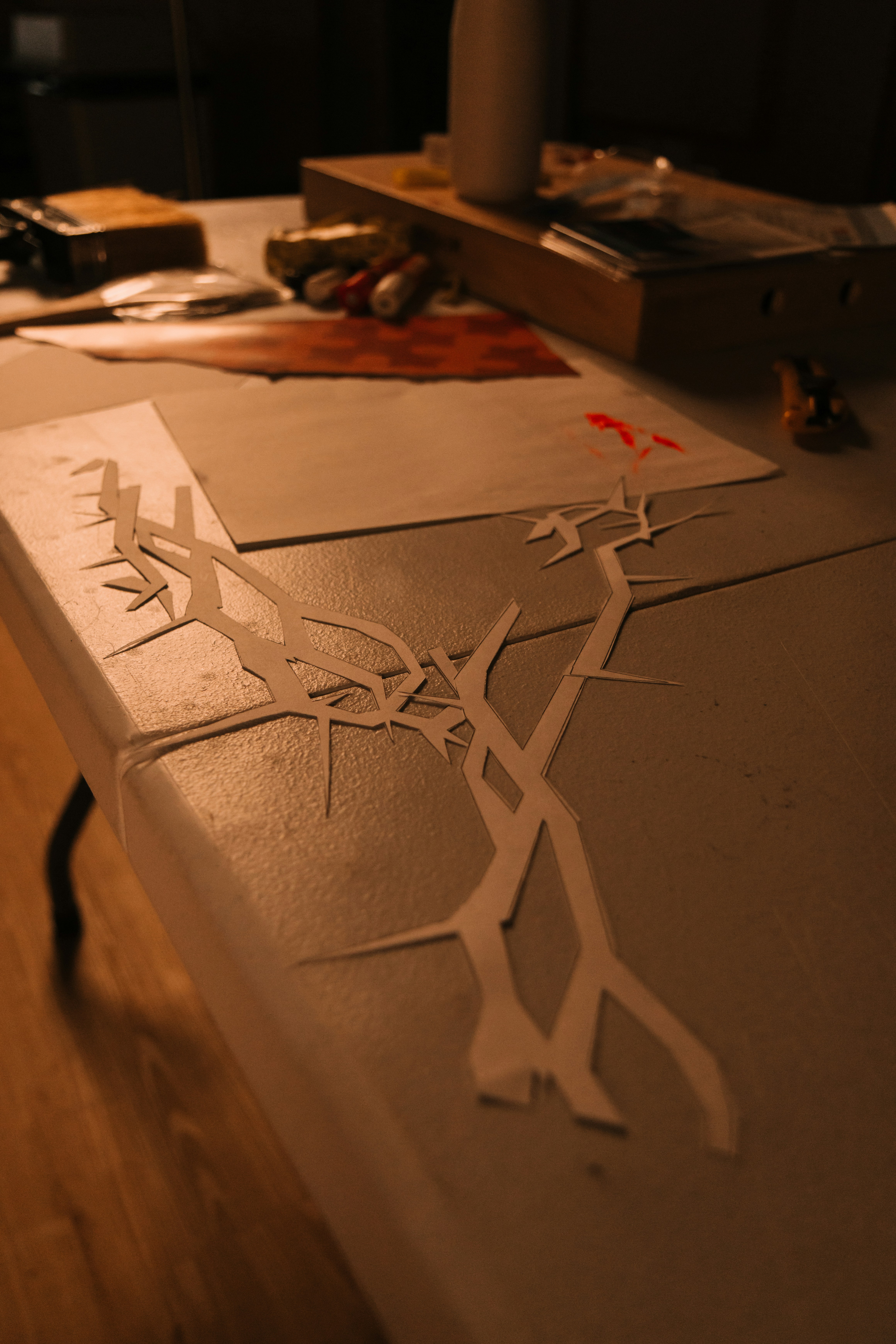 Paper cutouts of branches on a table.