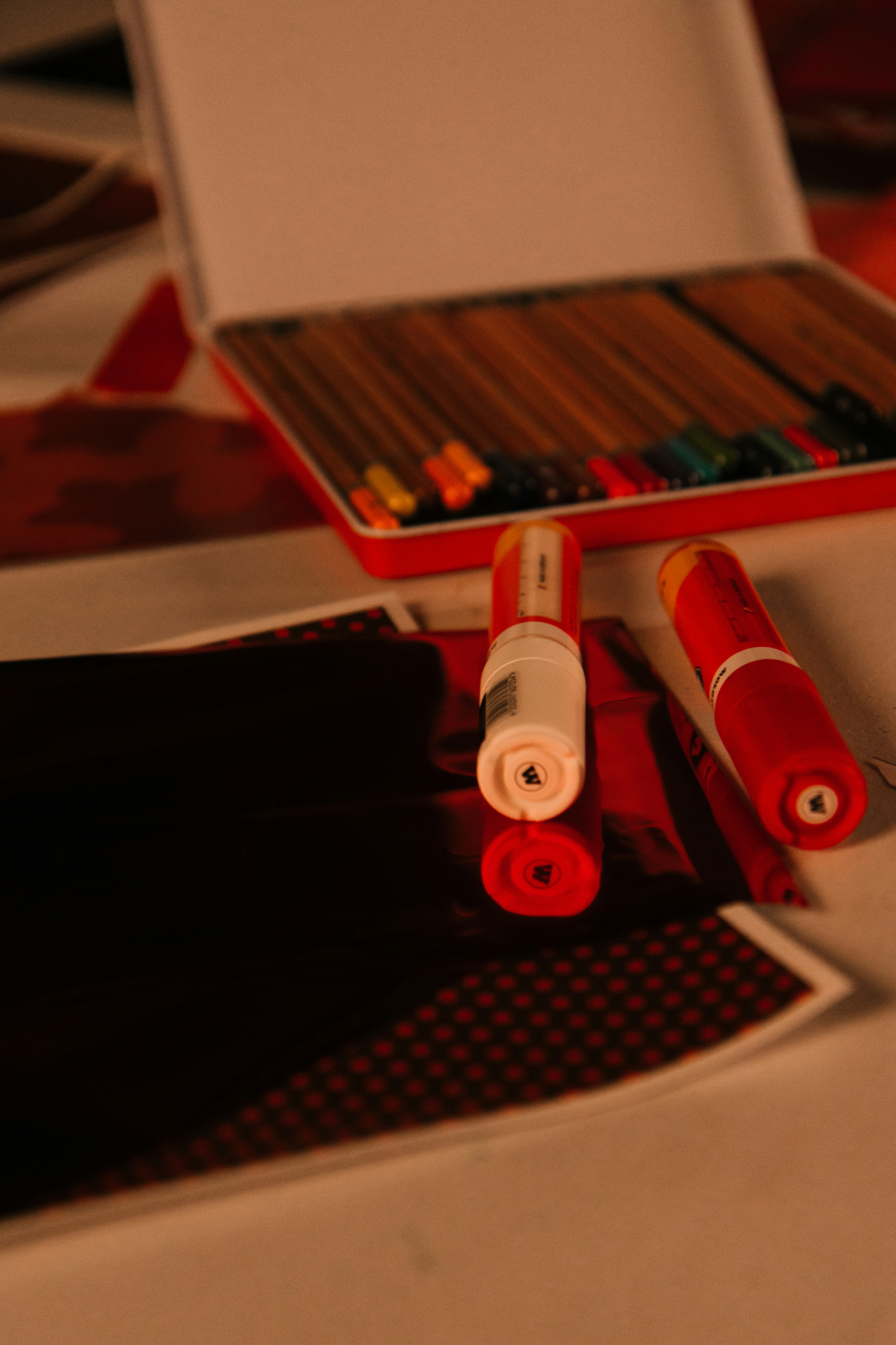 Colored pencils in a tin with crafting supplies.