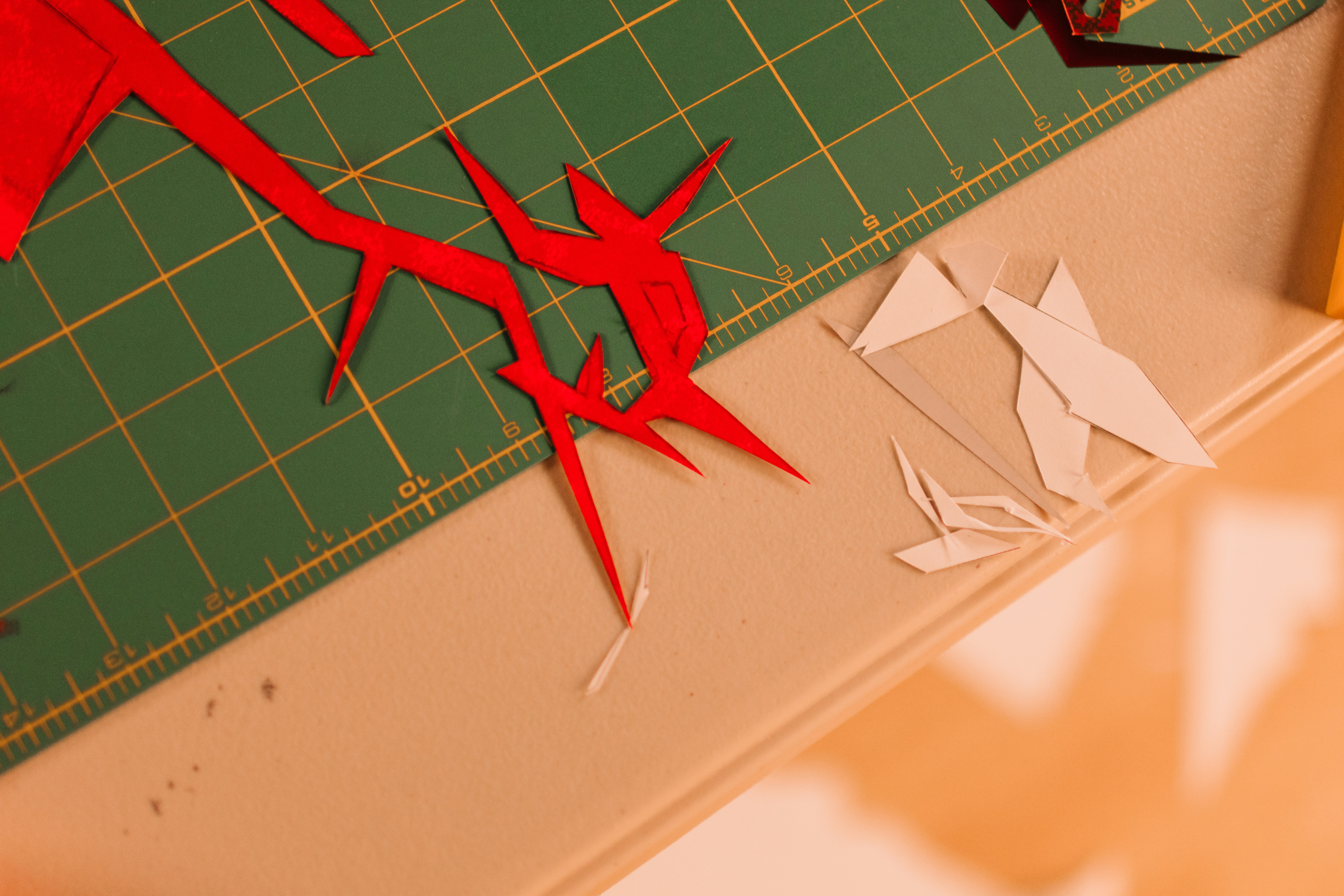 Rote Papierausschnitte auf einer grünen Schneidematte.