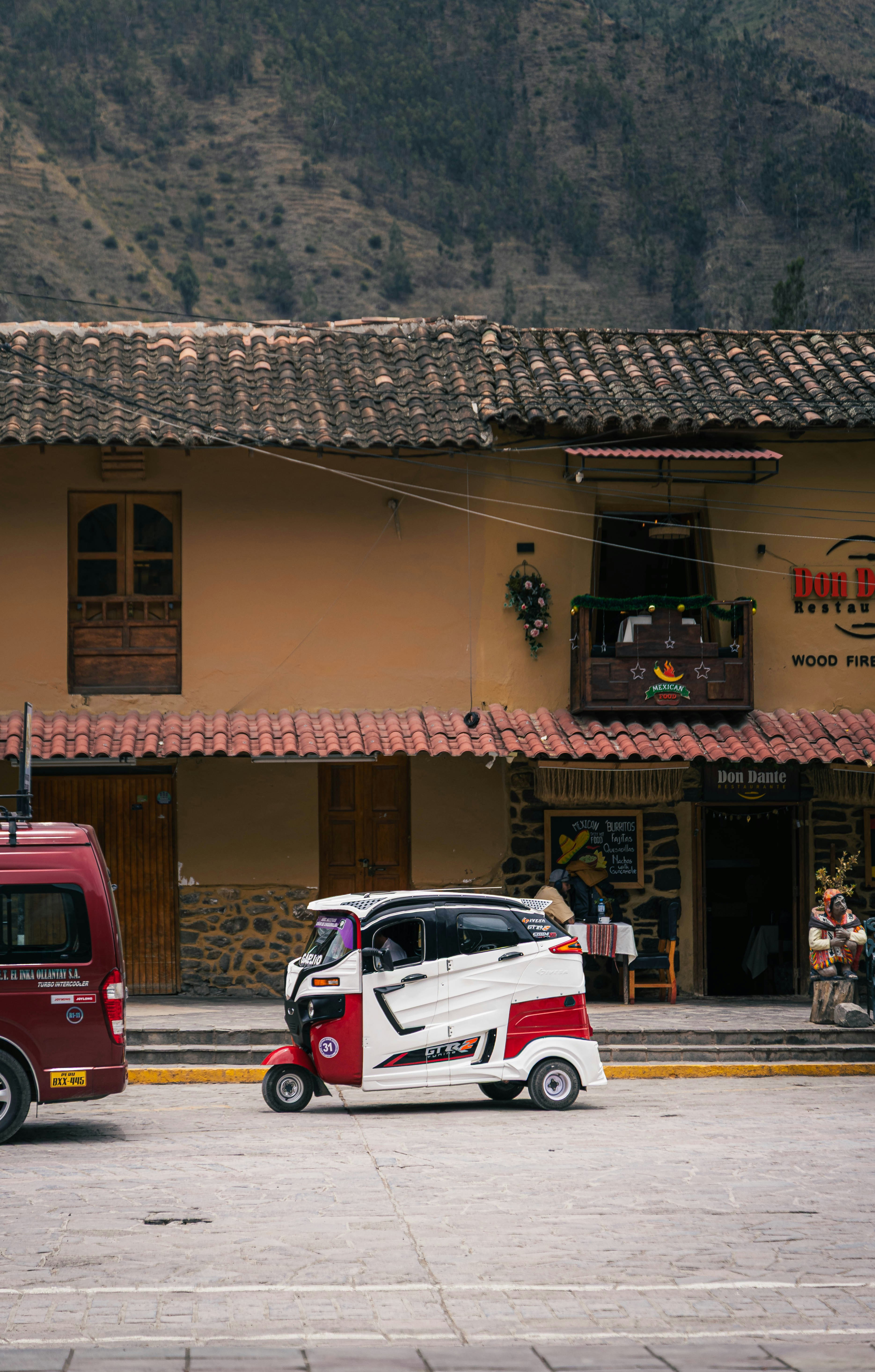 Eine rot-weiße Autorikscha auf einer Straße geparkt.