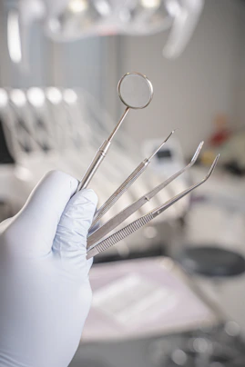 Gloved hand holding dental examination tools