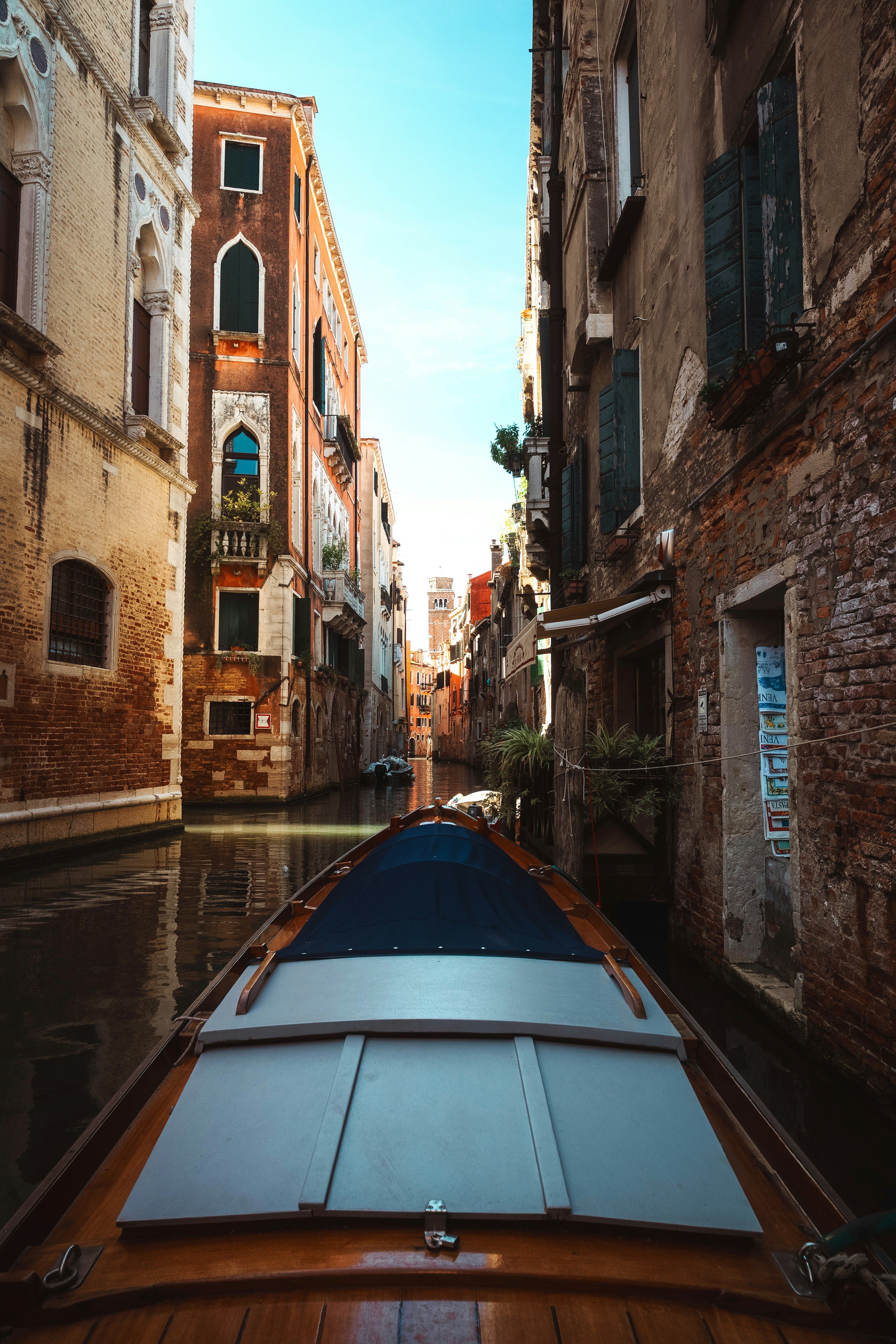 Boat moving down a narrow venetian canal