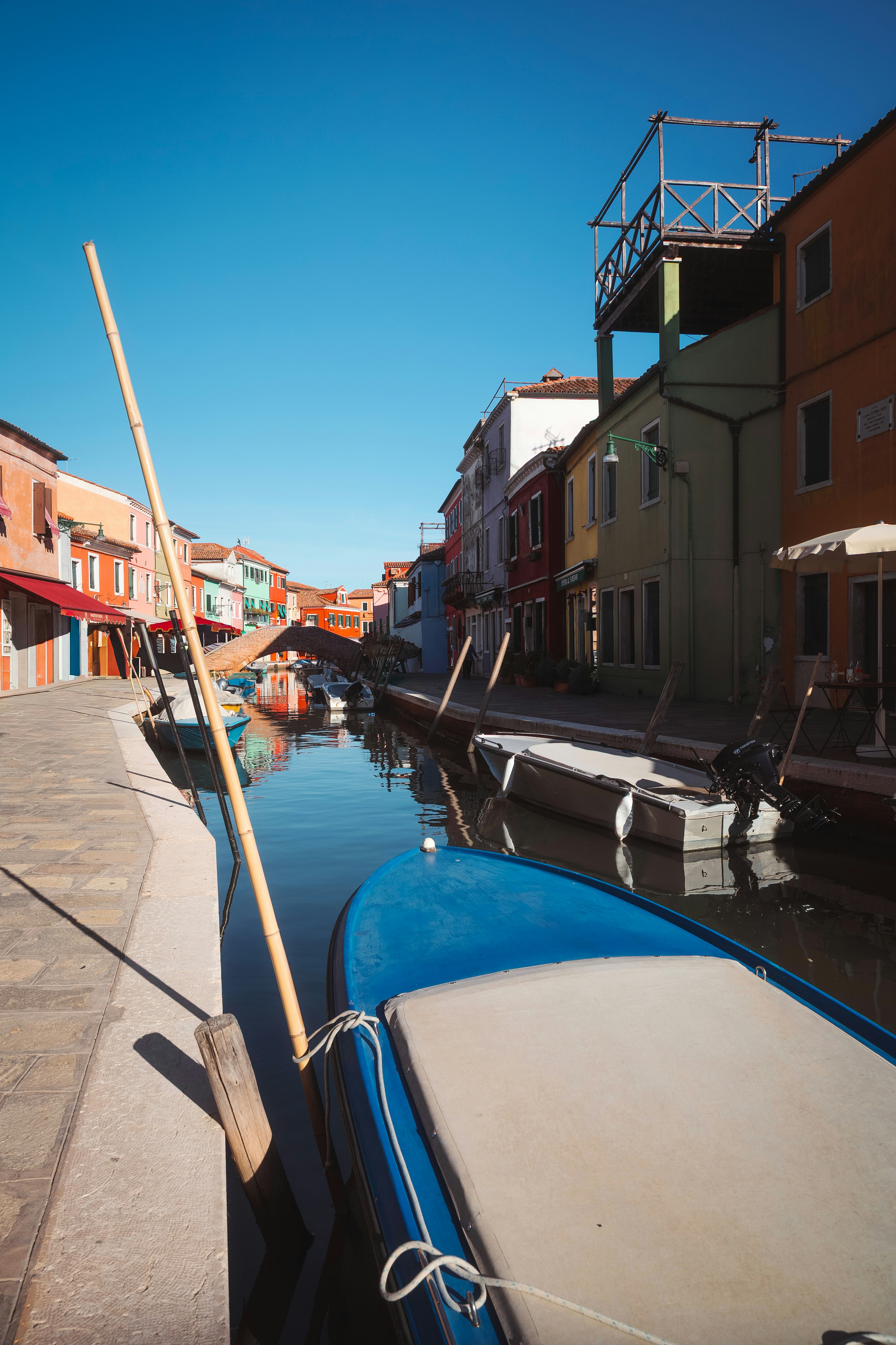 Colorful buildings line a canal with boats in burano, italy.