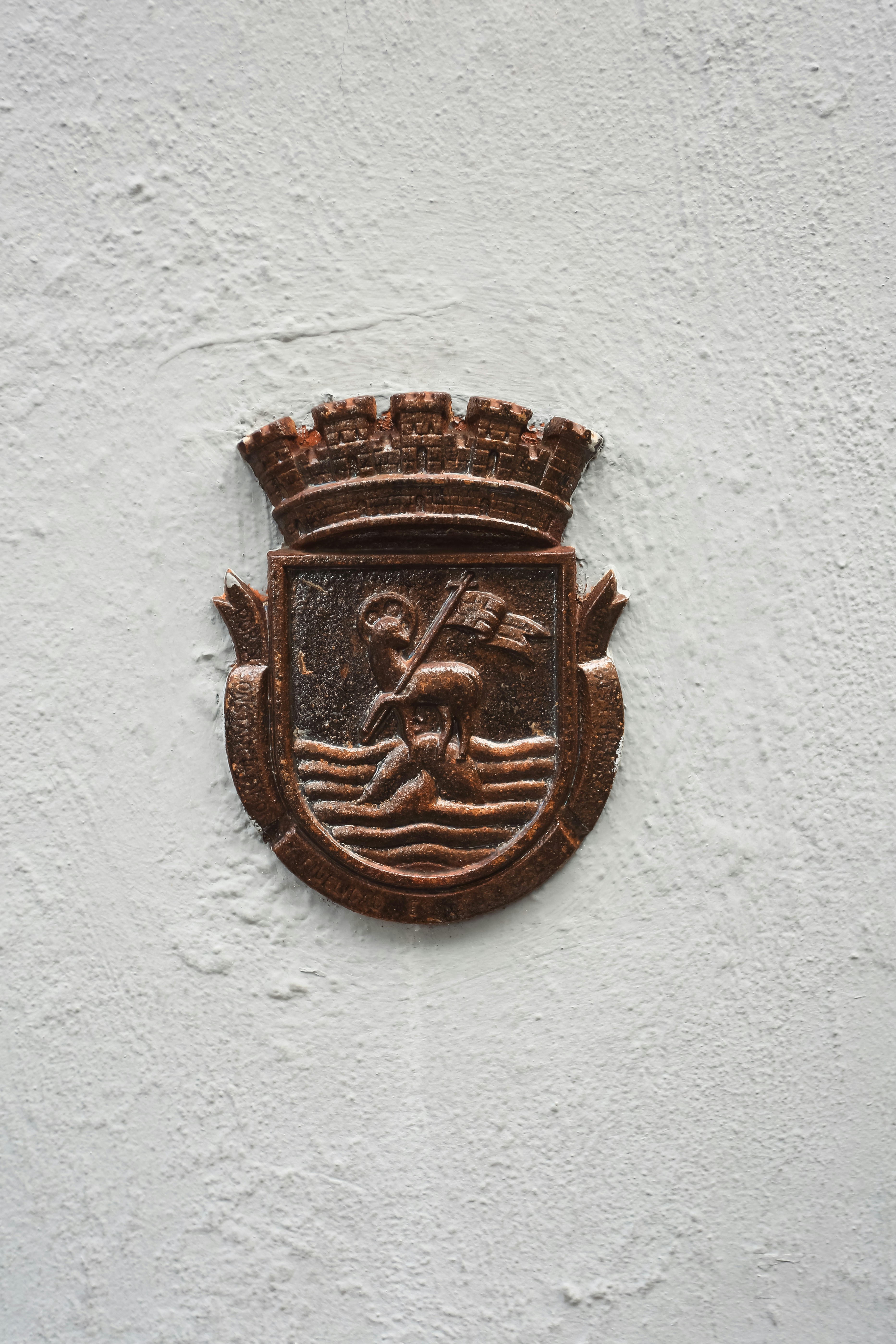 Escudo en relieve con una figura sosteniendo una bandera sobre las olas