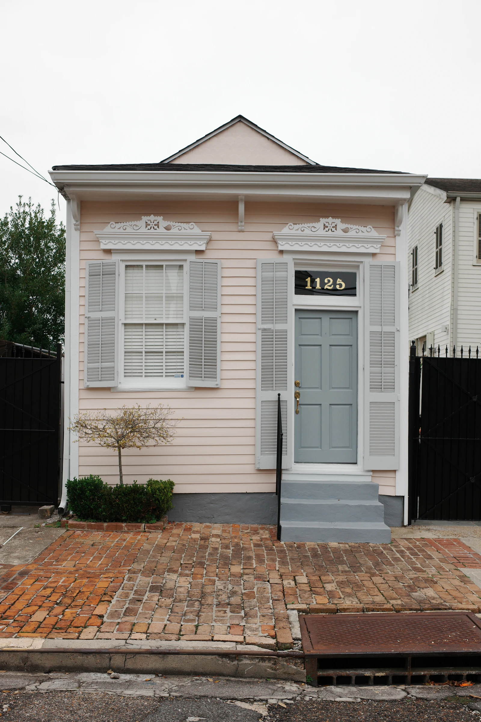 A small home with grey shutters and a tidy front yard.