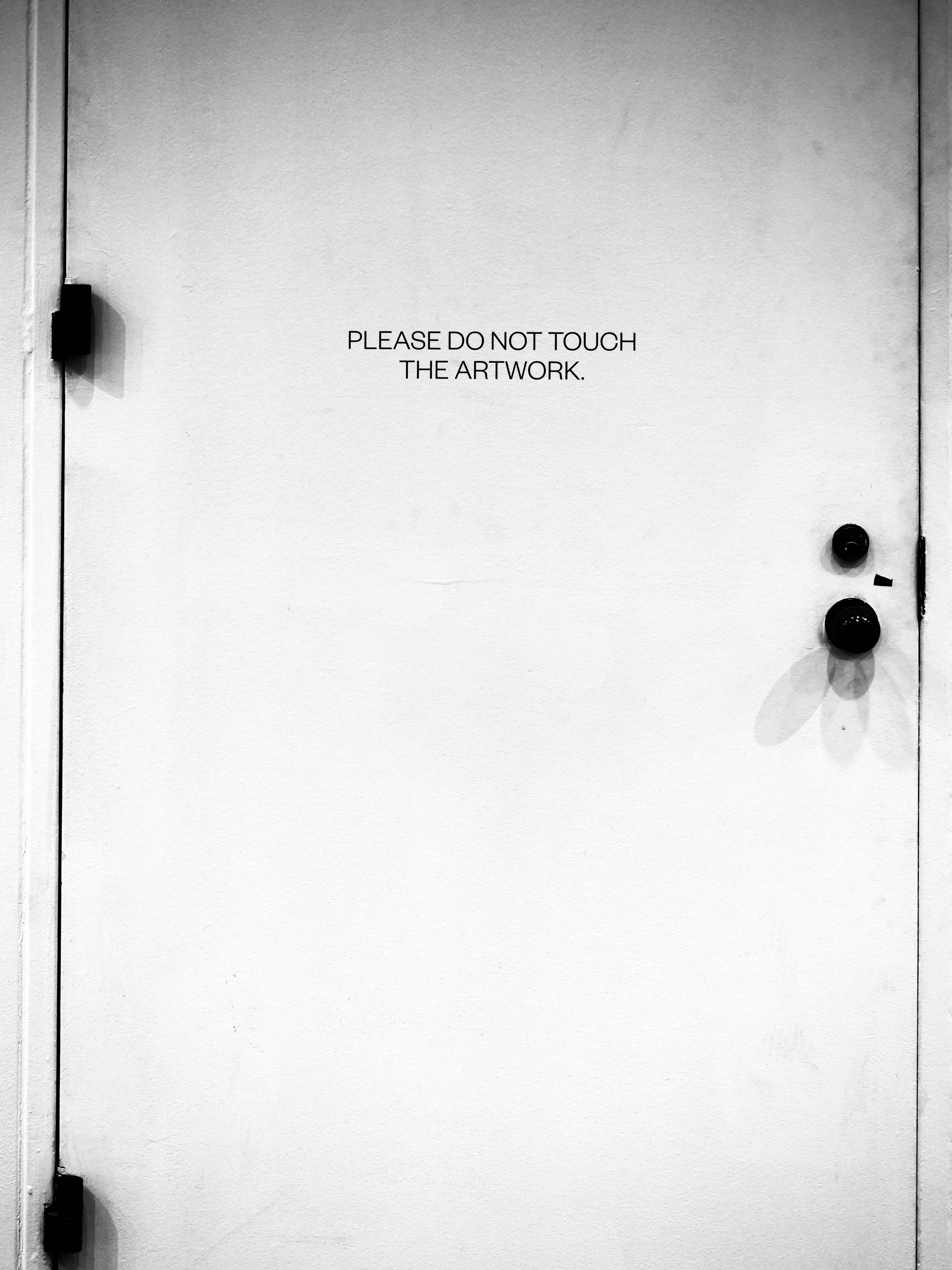 Weiße Tür mit dem Text "Bitte nicht das Kunstwerk anfassen".