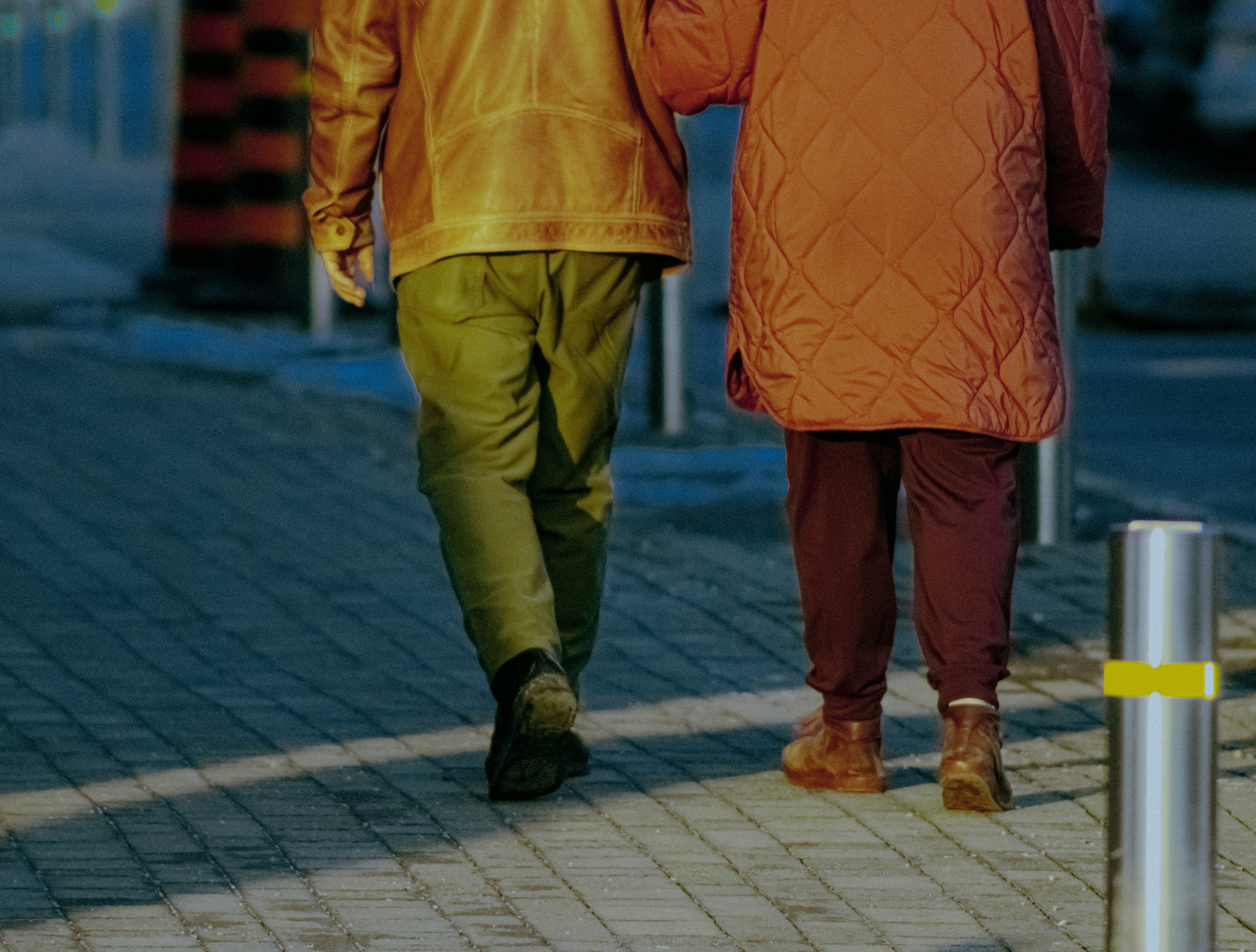Deux personnes marchant bras dessus bras dessus sur un trottoir