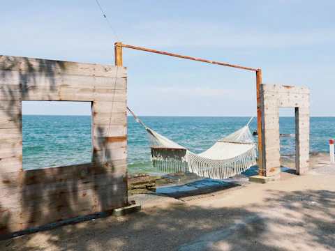 Hammock strung between wooden frames by the ocean