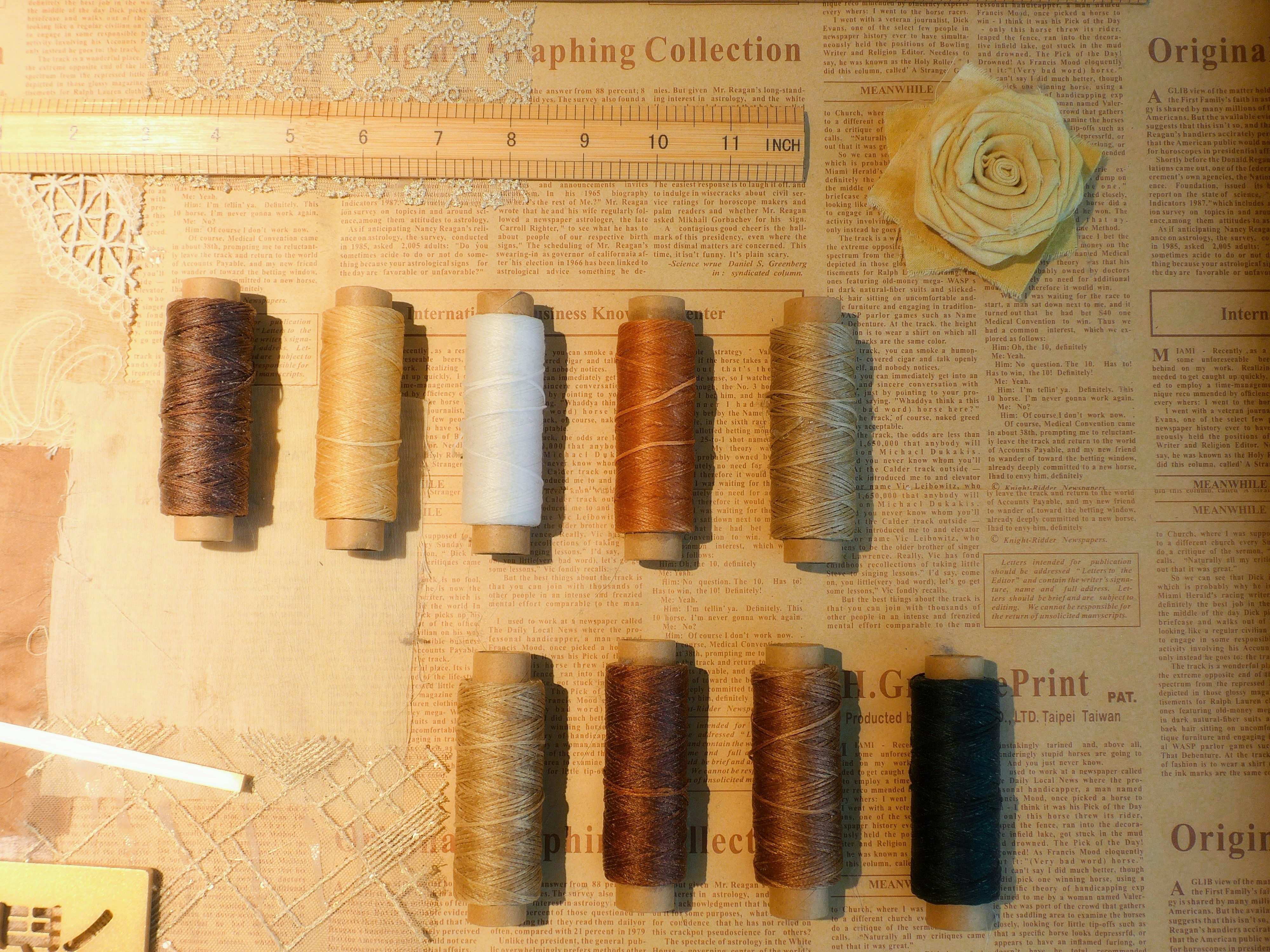 Spools of thread in various colors arranged on paper