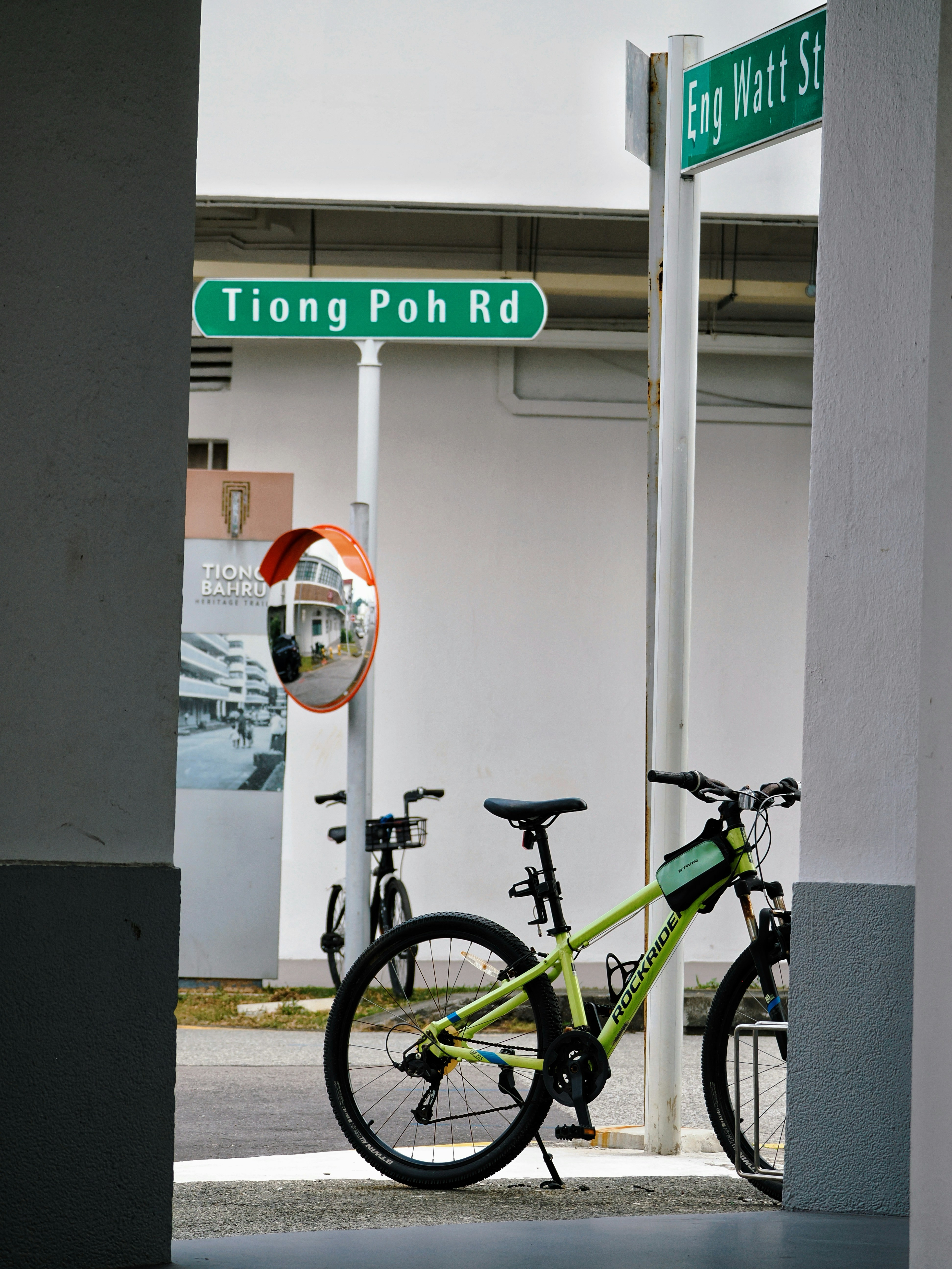 Bicycles parked near street signs on a cloudy day.