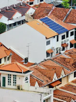 Rooftops of houses with solar panels on one roof.