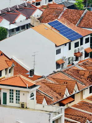 Rooftops of houses with solar panels on one roof.
