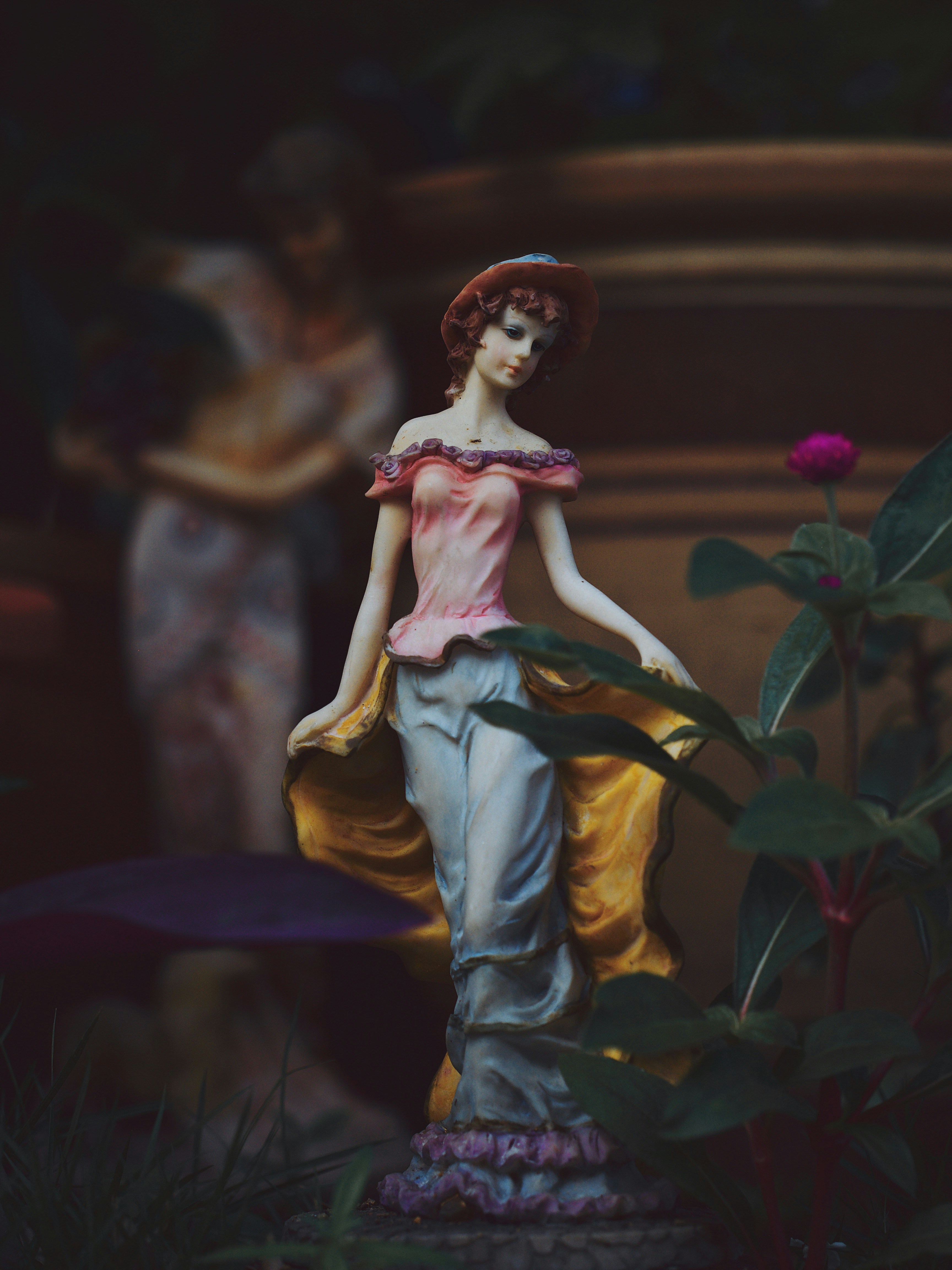 A delicate figurine of a woman in a garden