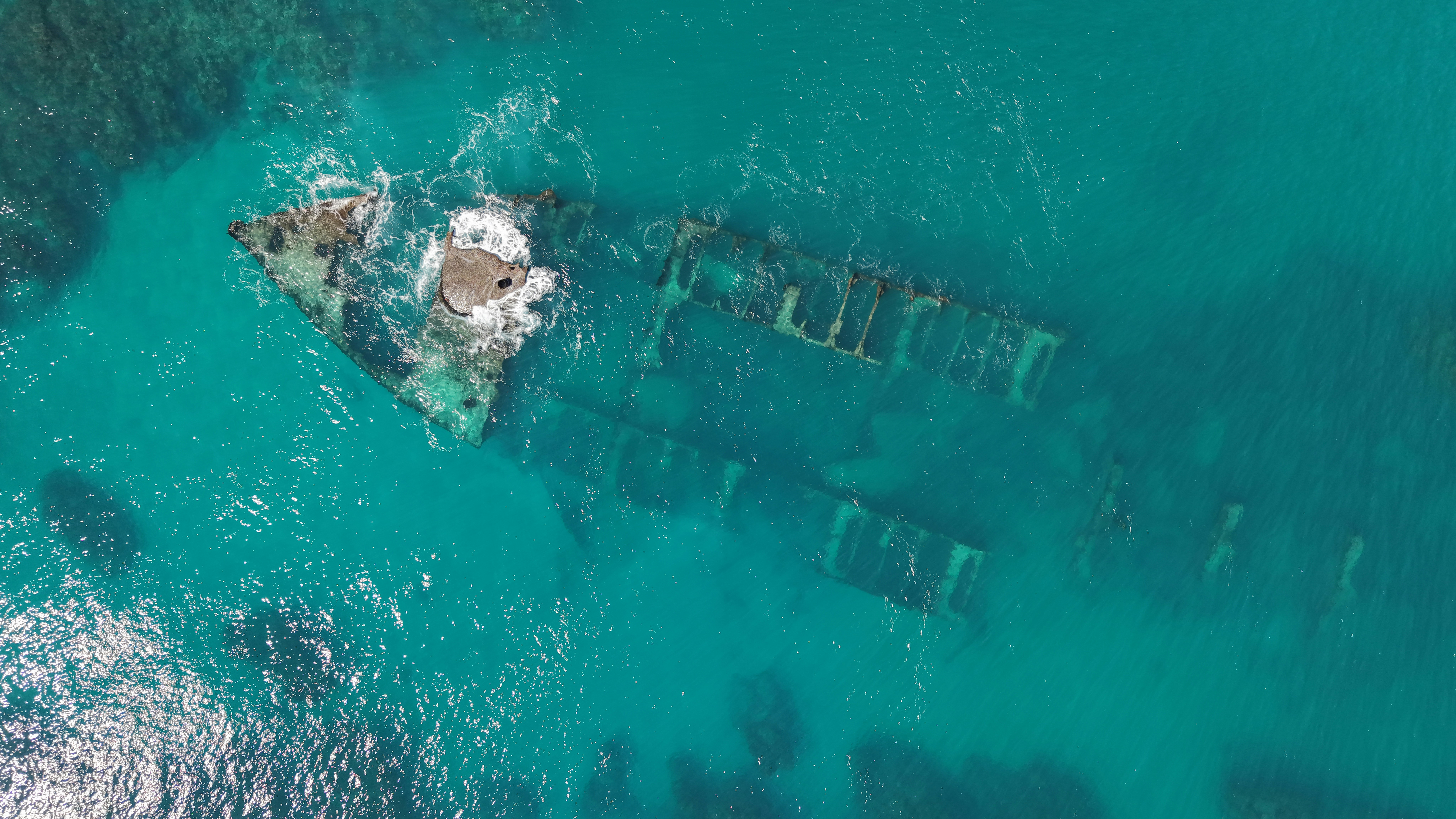 Shipwreck submerged in clear turquoise ocean water