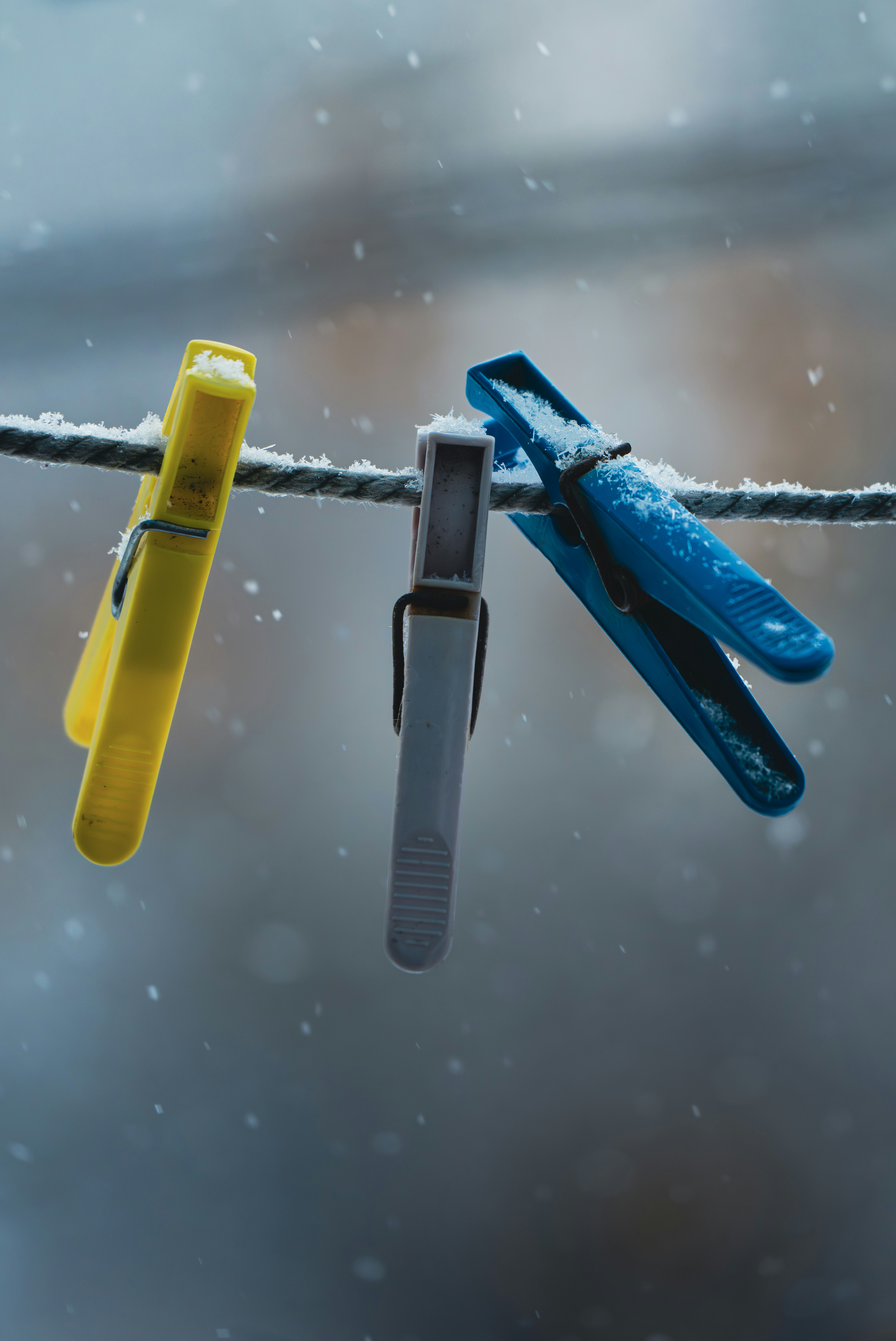 Three clothespins on a snowy clothesline