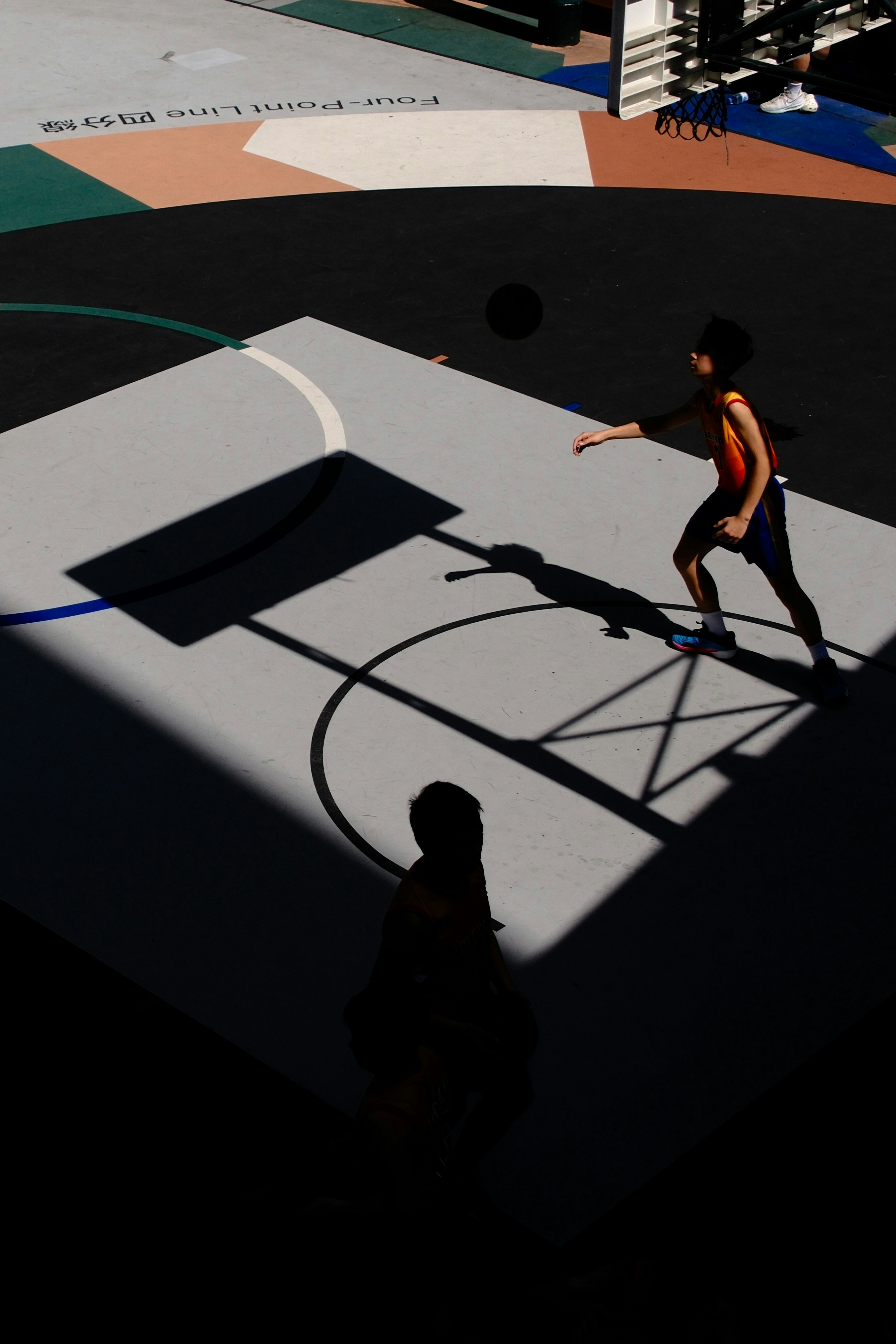 Eine Person, die auf einem Spielfeld Basketball spielt.