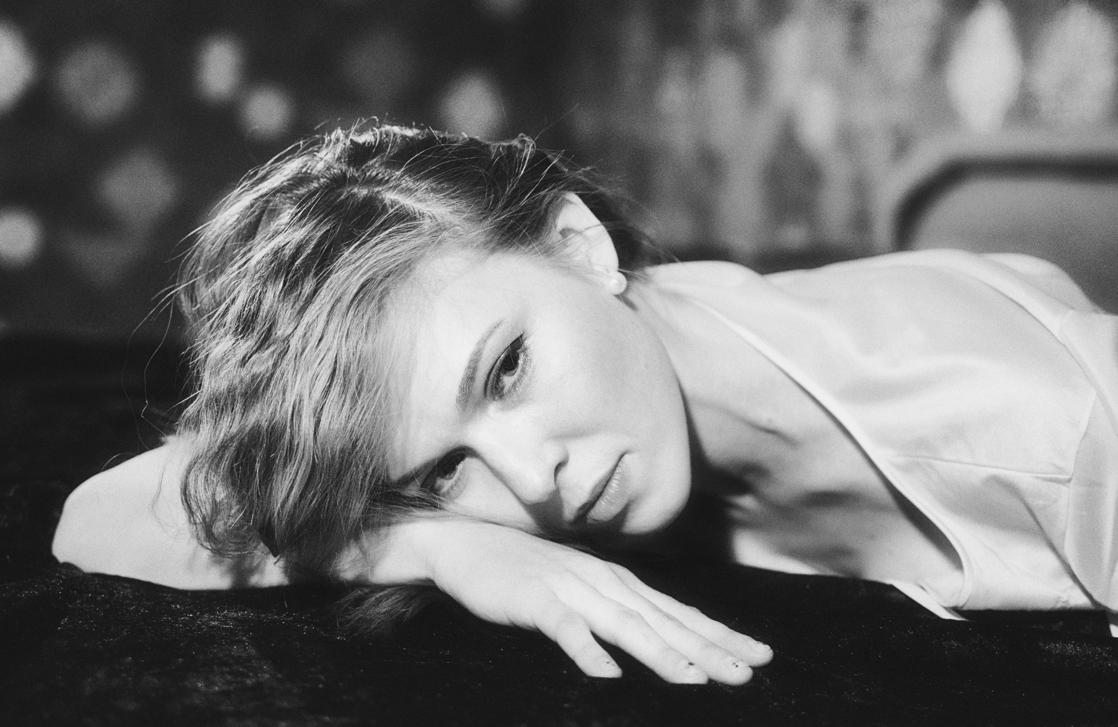 Une femme pose sa tête sur sa main.